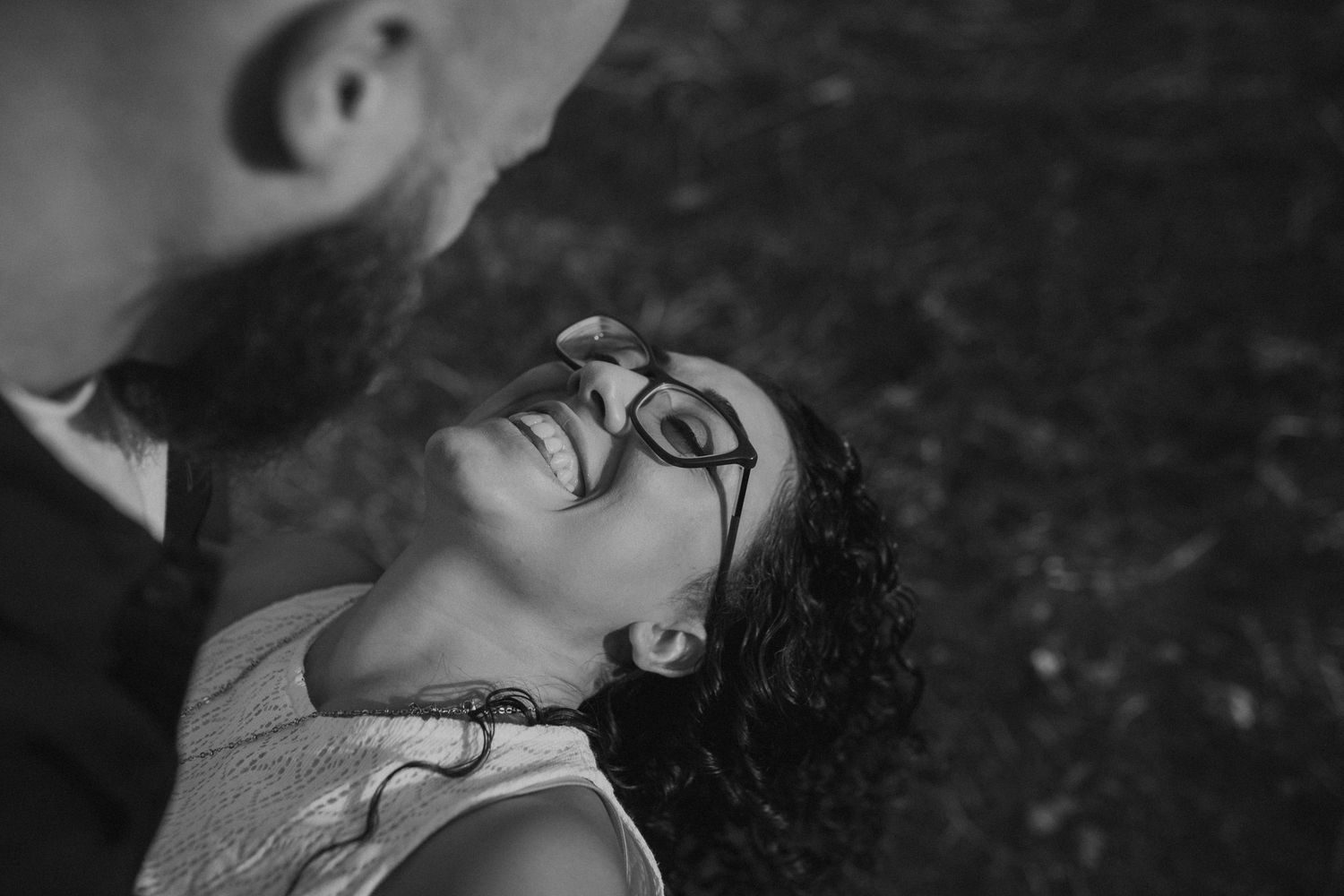 Two people lying down together in a romantic black and white photo shoot.