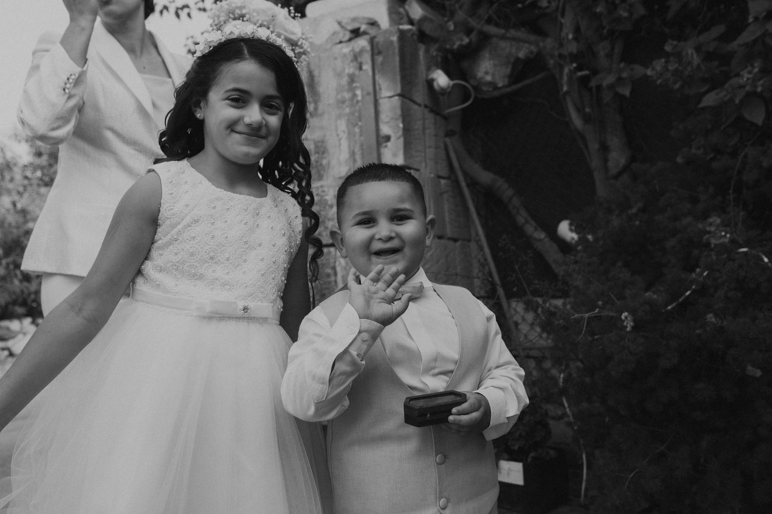 Black and white candid wedding moments with children enjoying the celebration.