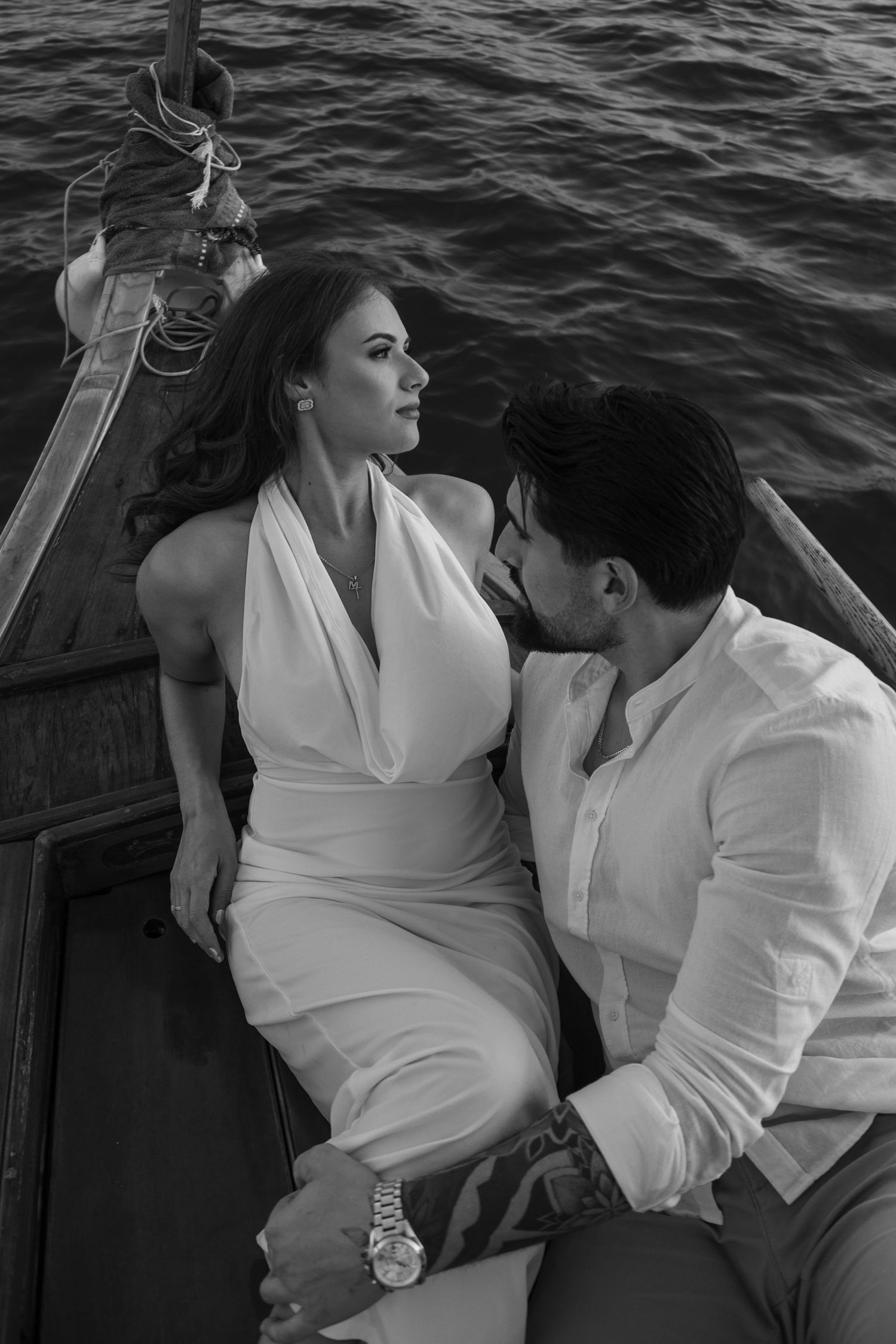 Romantic black and white boat photoshoot showing tender moments between a couple.