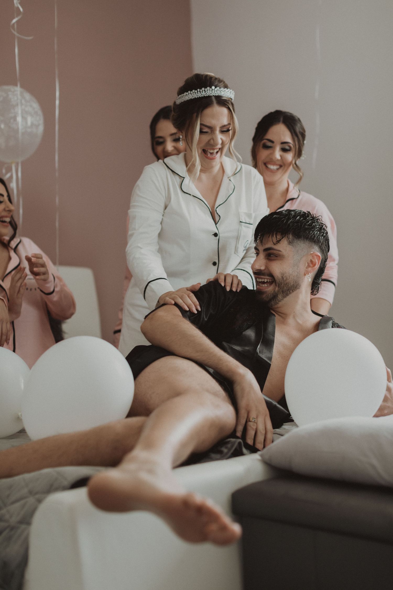 Candid pre-wedding moments captured with wedding party in casual attire surrounded by white balloons.