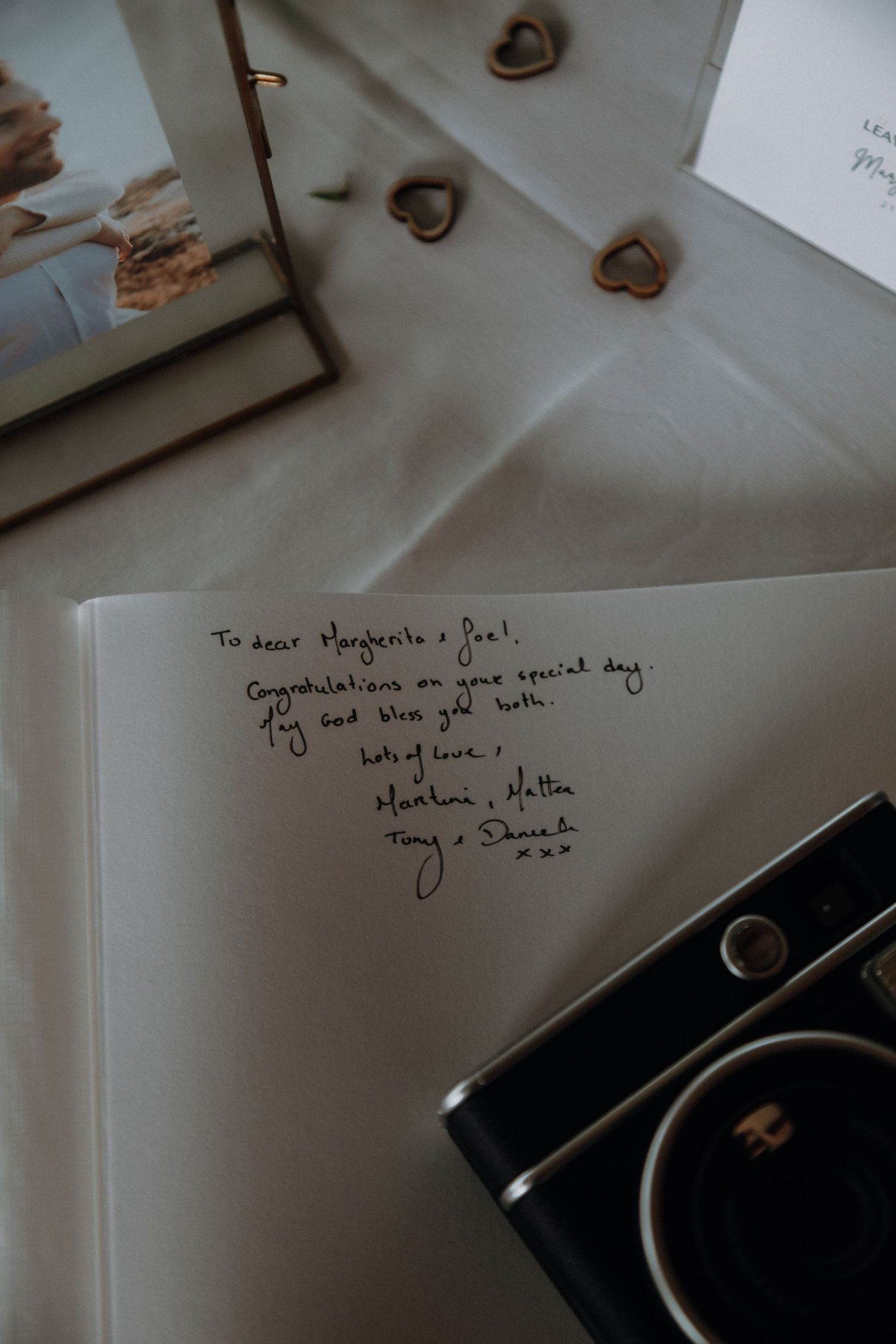 Handwritten wedding guest book message with decorative hearts.