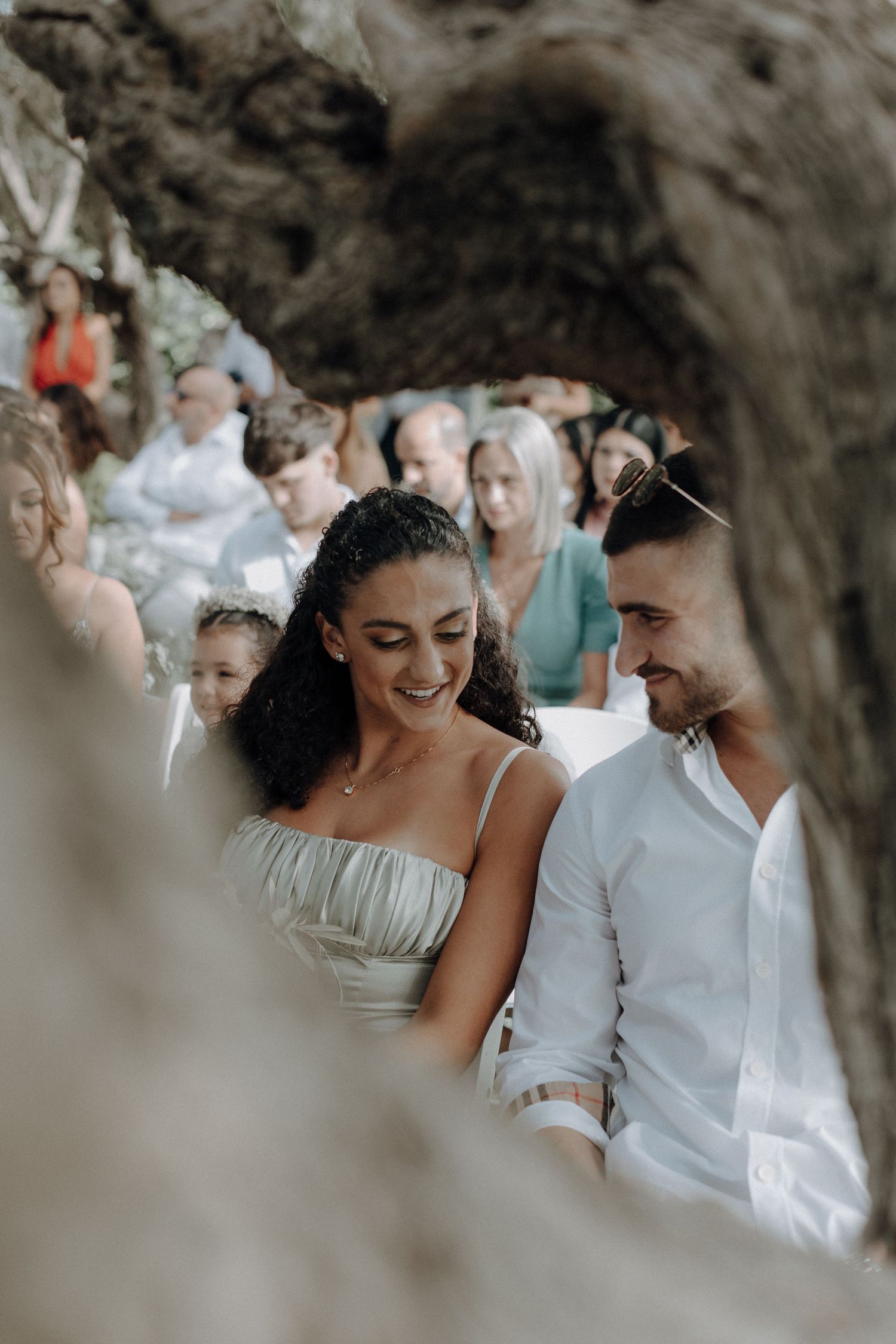 A couple shares an intimate moment during their wedding ceremony under a natural stone archway.