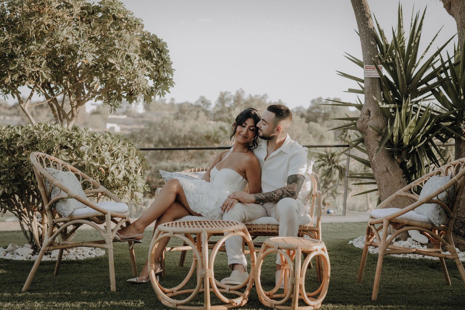 Elegant outdoor wedding setup with palm trees and natural decor.
