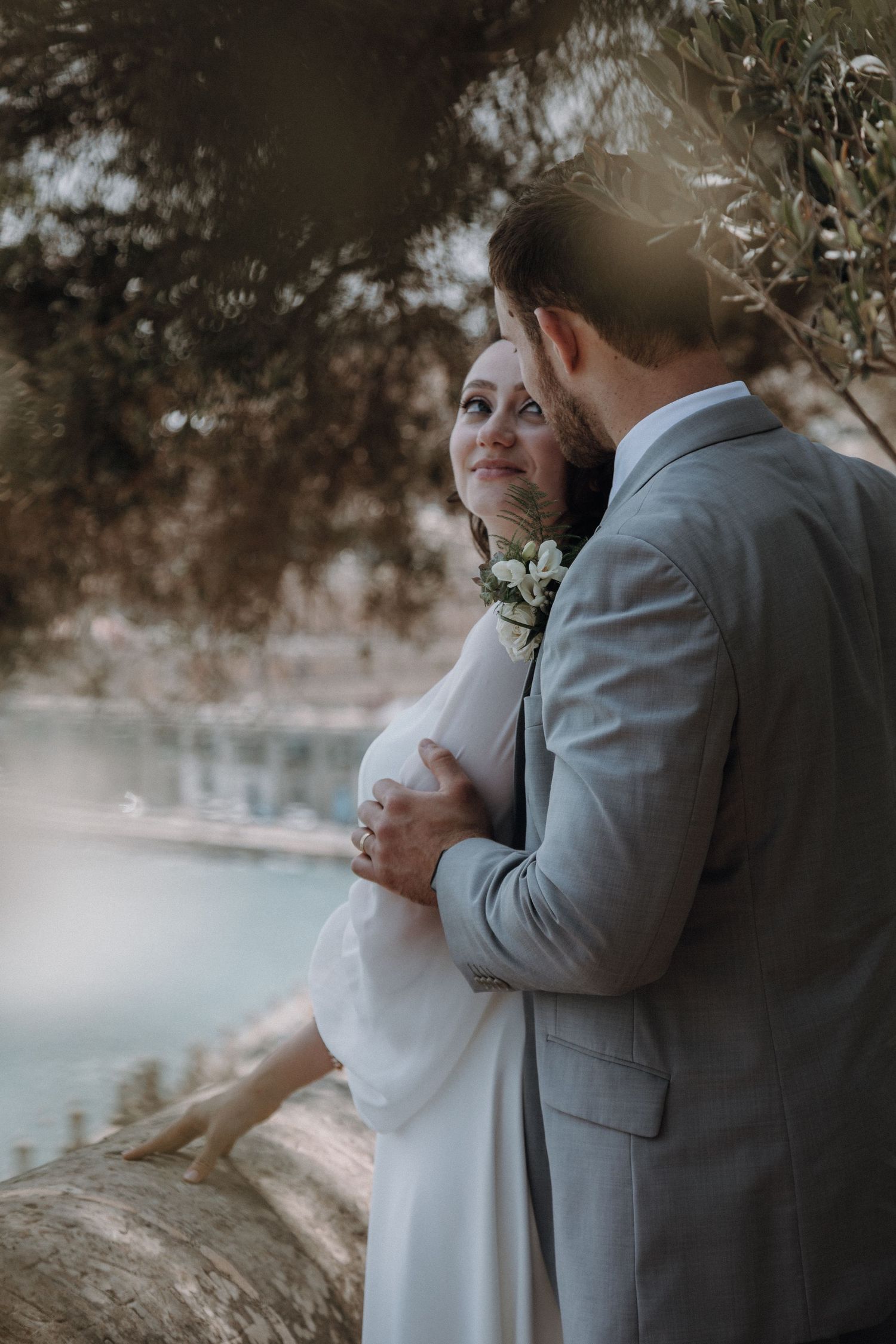 Intimate wedding portrait with waterfront and sunlight.