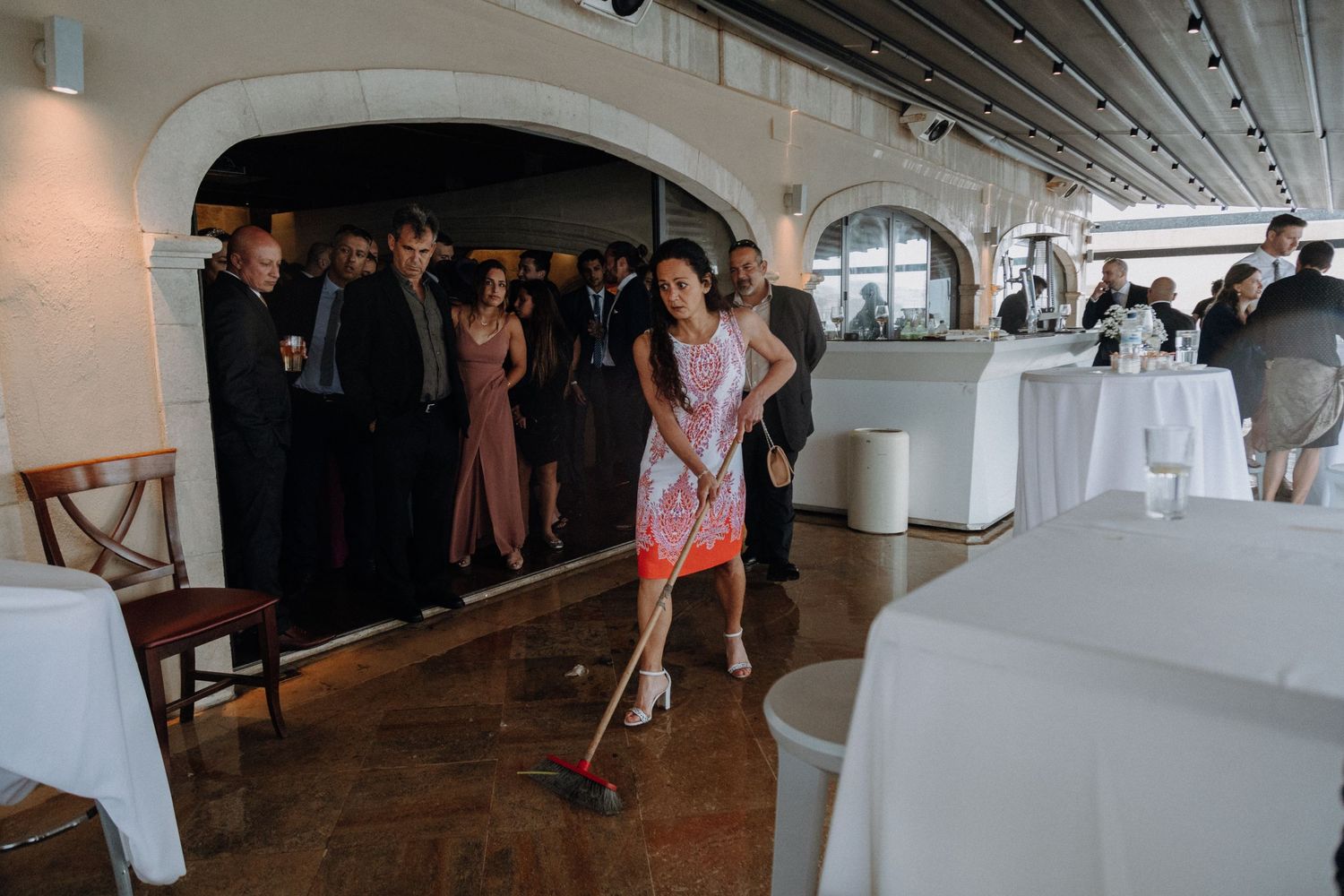Party guests mingling in an elegant white reception venue.