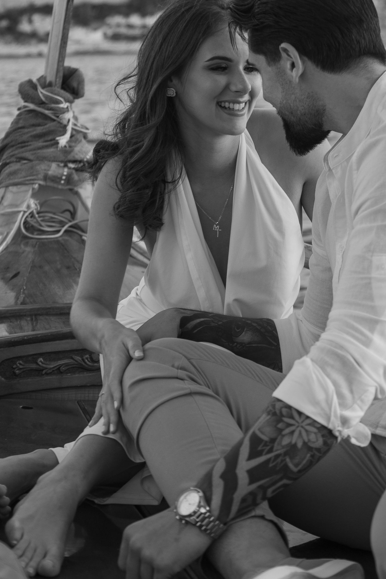 Candid black and white photos capturing intimate moments between a couple on a boat.