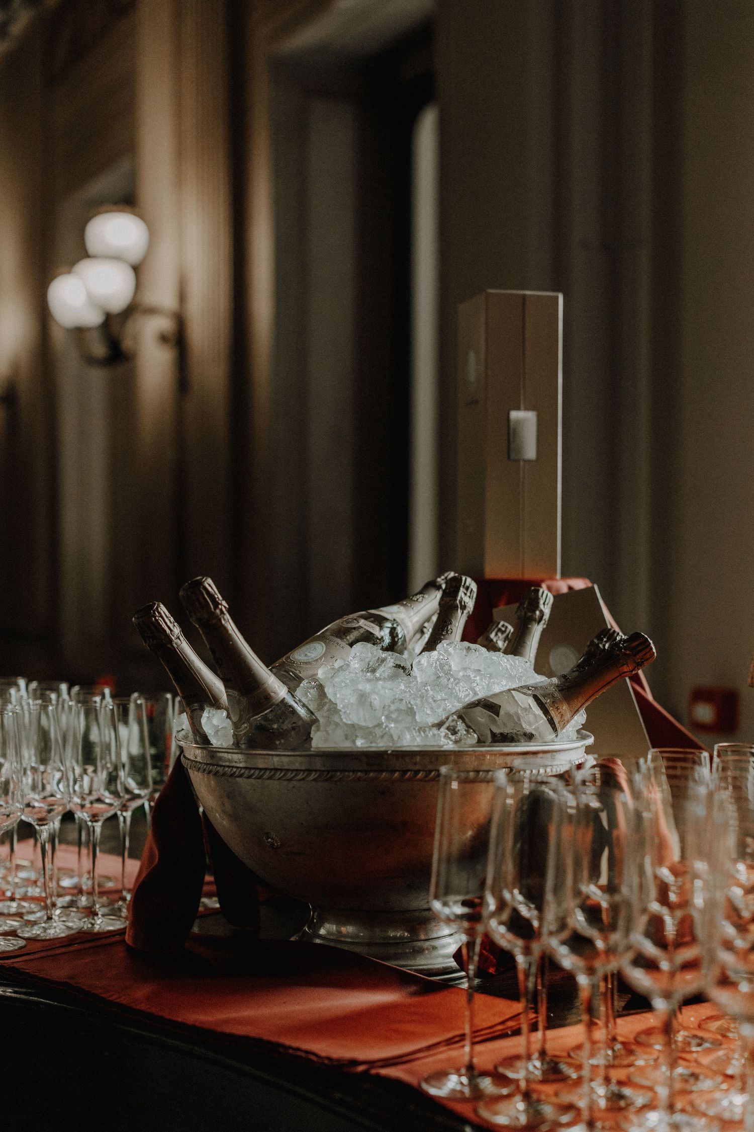 Elegant bar setup with champagne bottles on ice and crystal glassware.