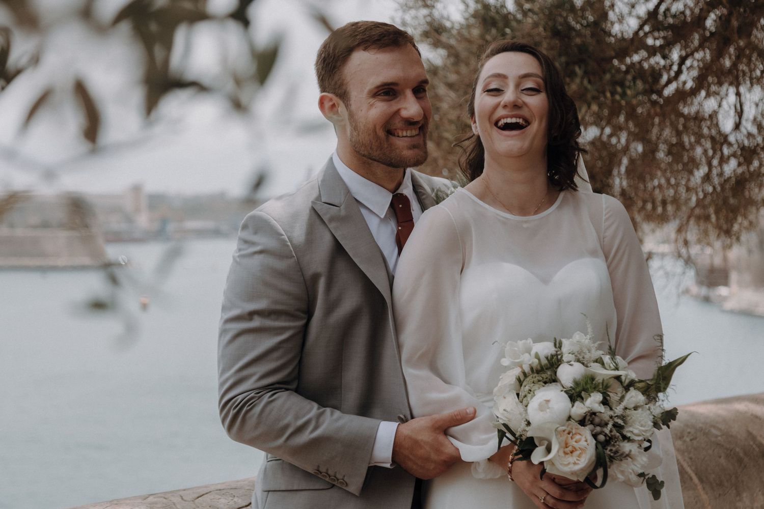 Wedding couple sharing joyful moments together in an outdoor setting.