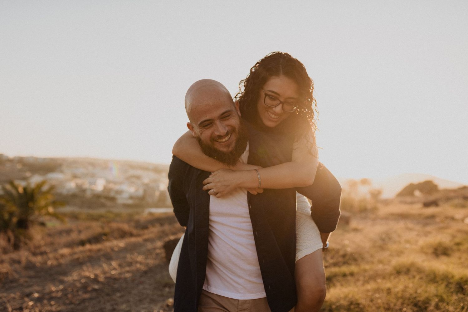Romantic couple embracing during sunset photoshoot outdoors.