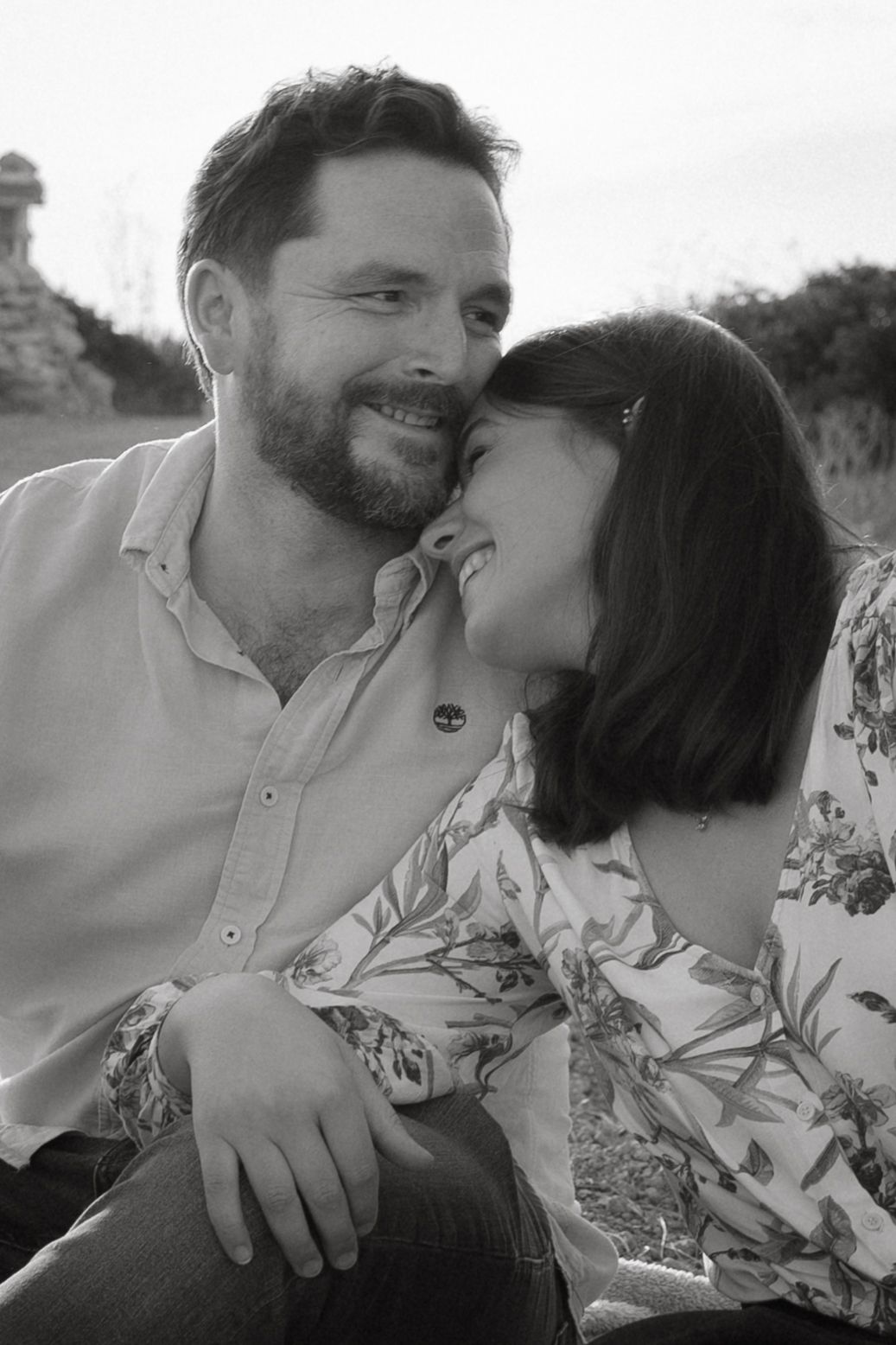A couple shares intimate moments in a series of black and white photographs outdoors.