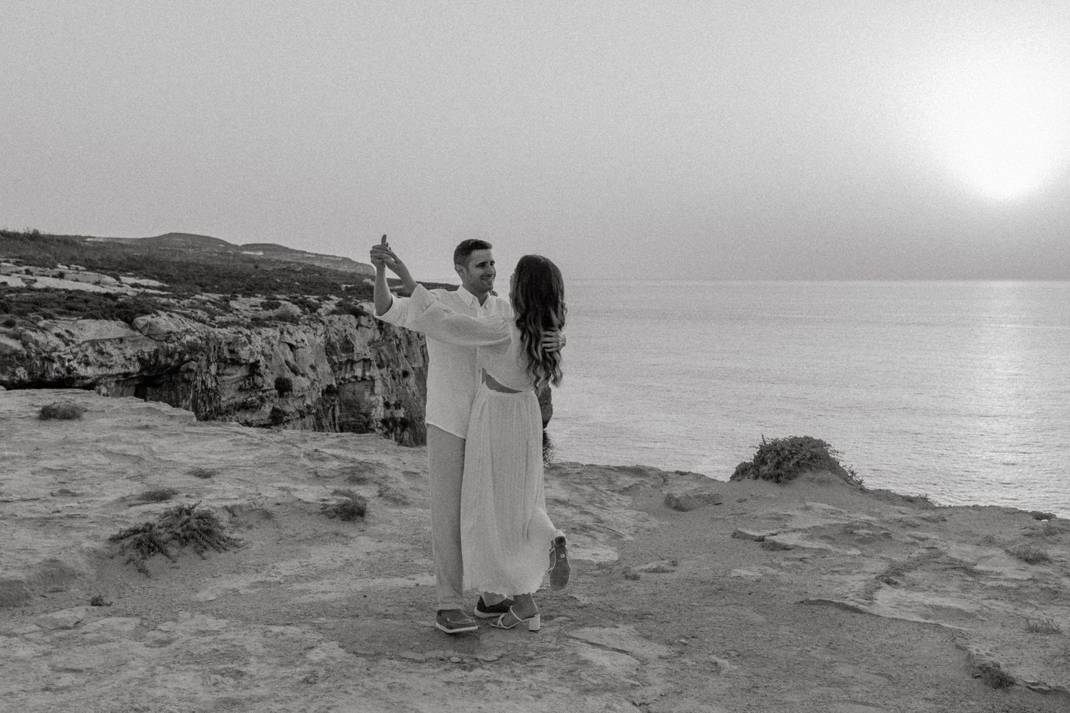 A couple walks along the seaside cliffs during a dreamy photoshoot.