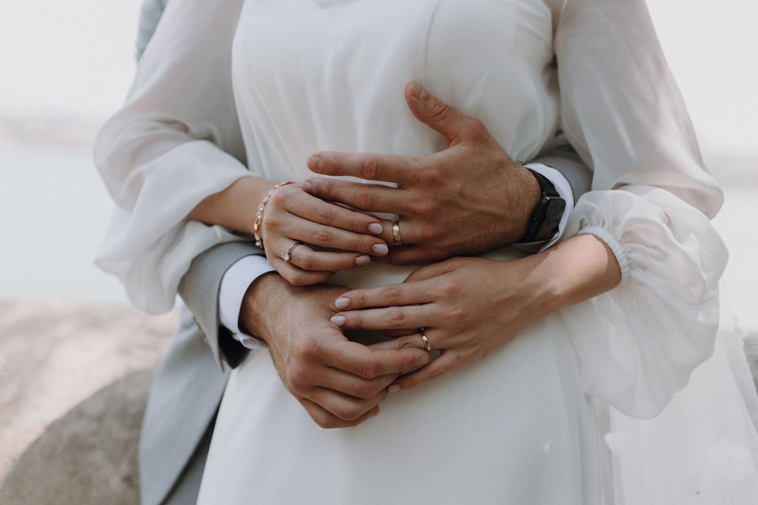 Intimate wedding portraits showing hands and embraces in muted tones.