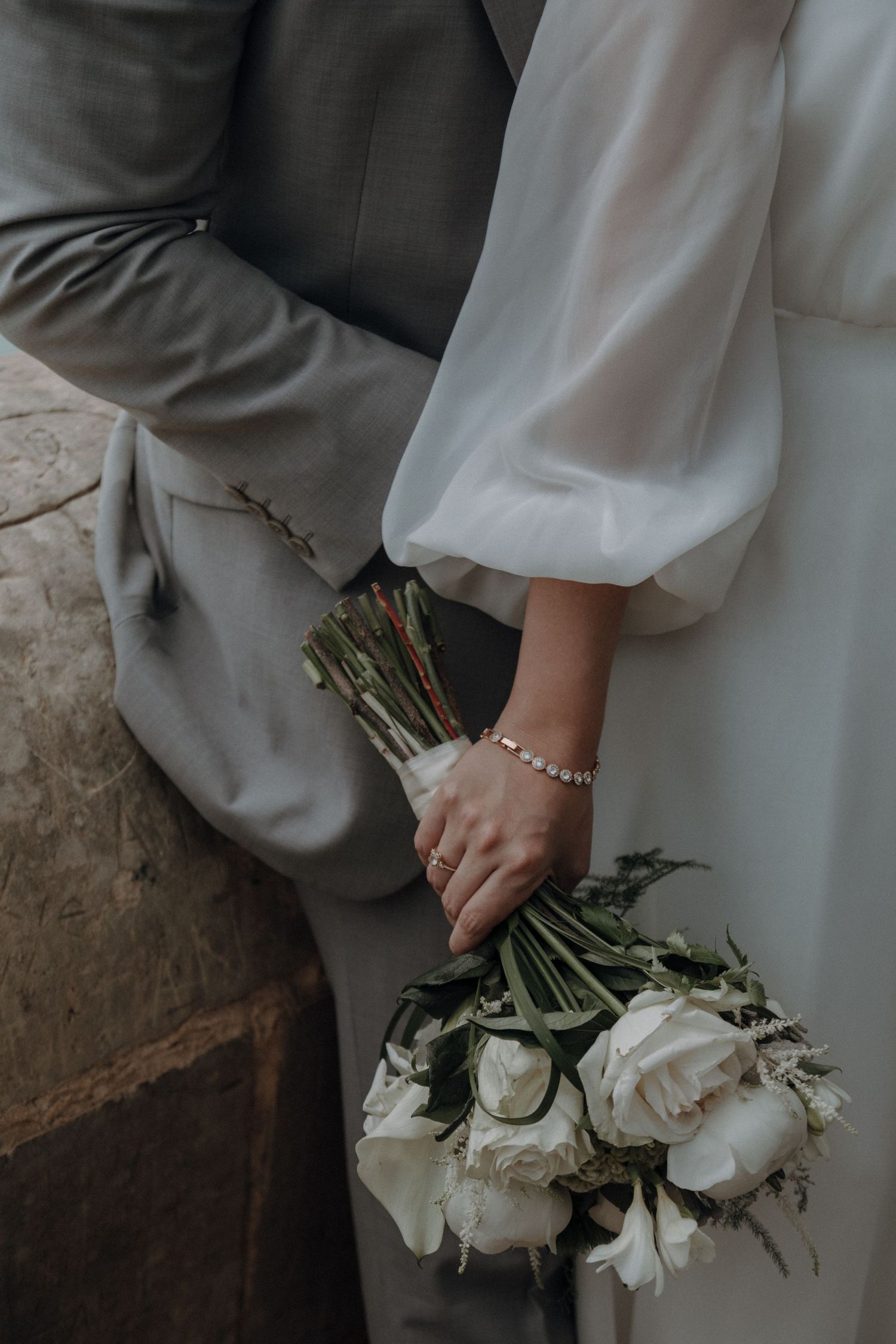 Detail shots of wedding attire and white rose bouquet in elegant styling.