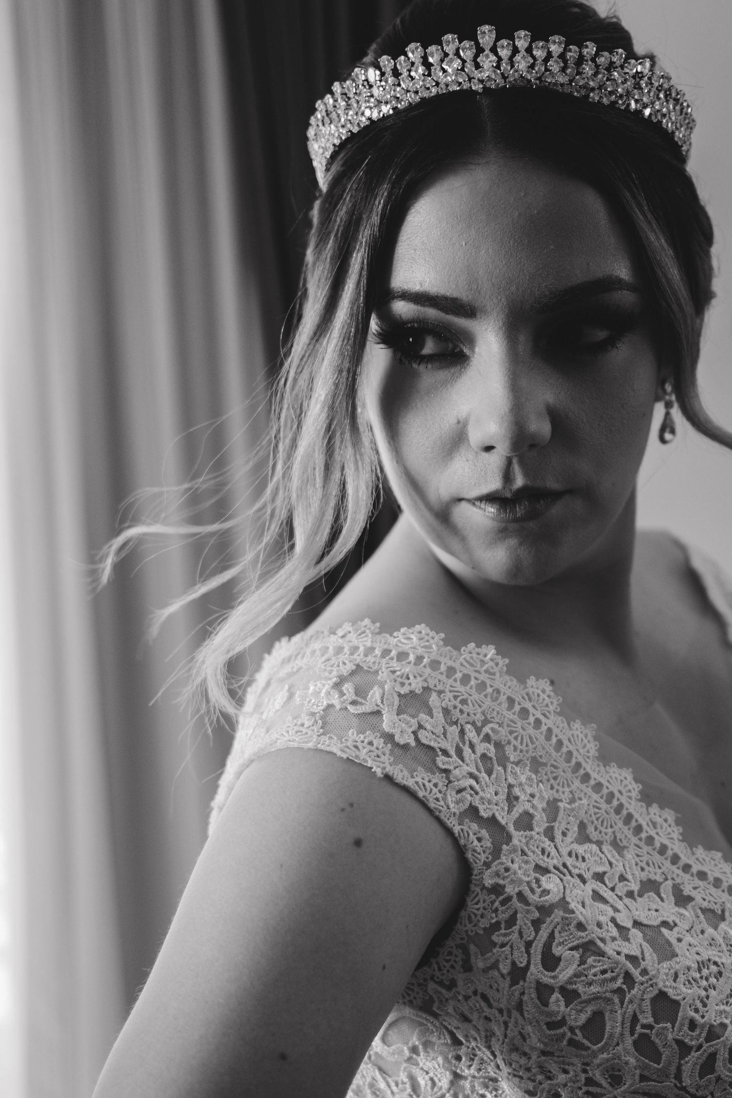 Close-up details of bridal accessories including a crystal tiara and lace bodice in monochrome.