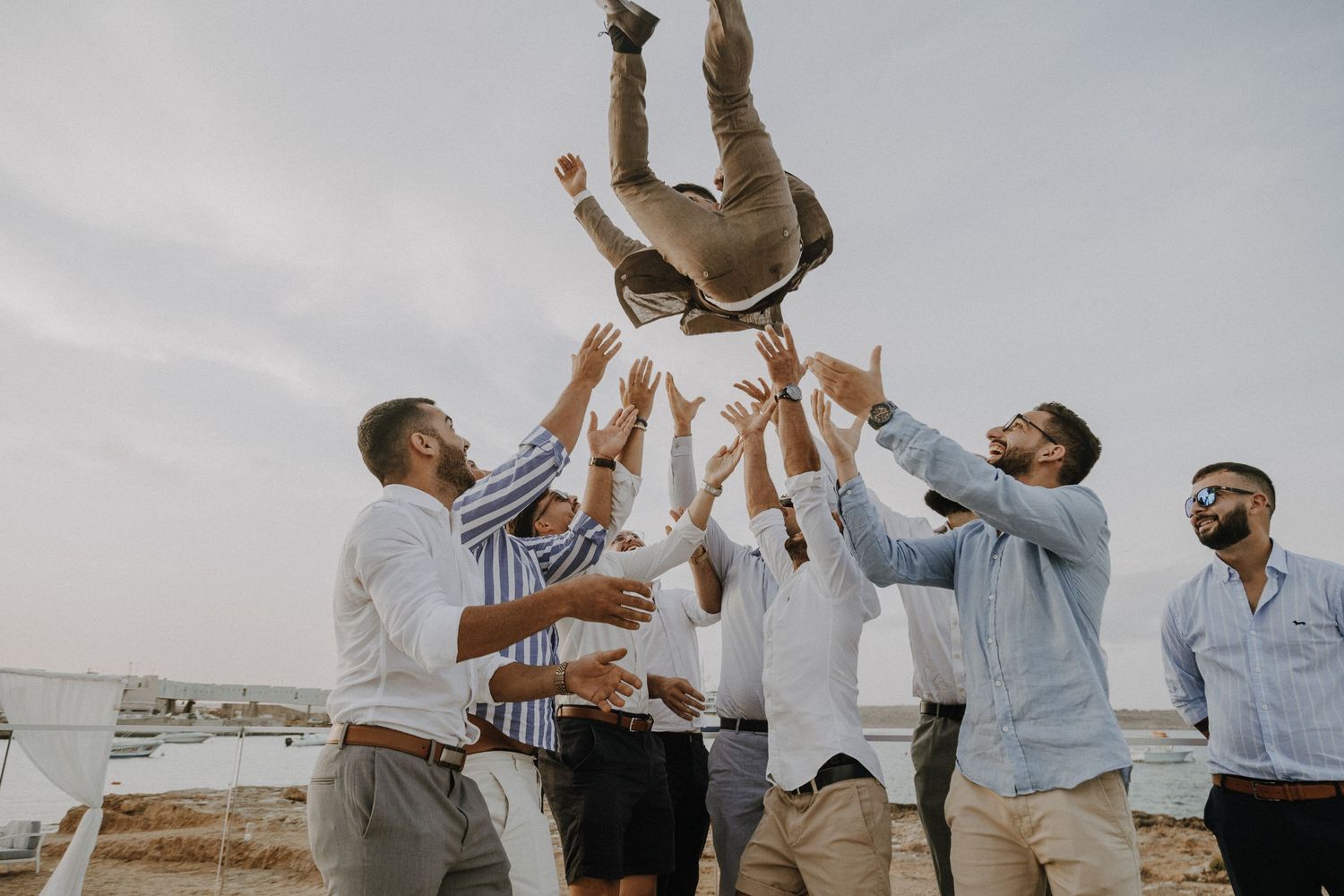A joyful group celebration with people leaping and raising their arms in unison.