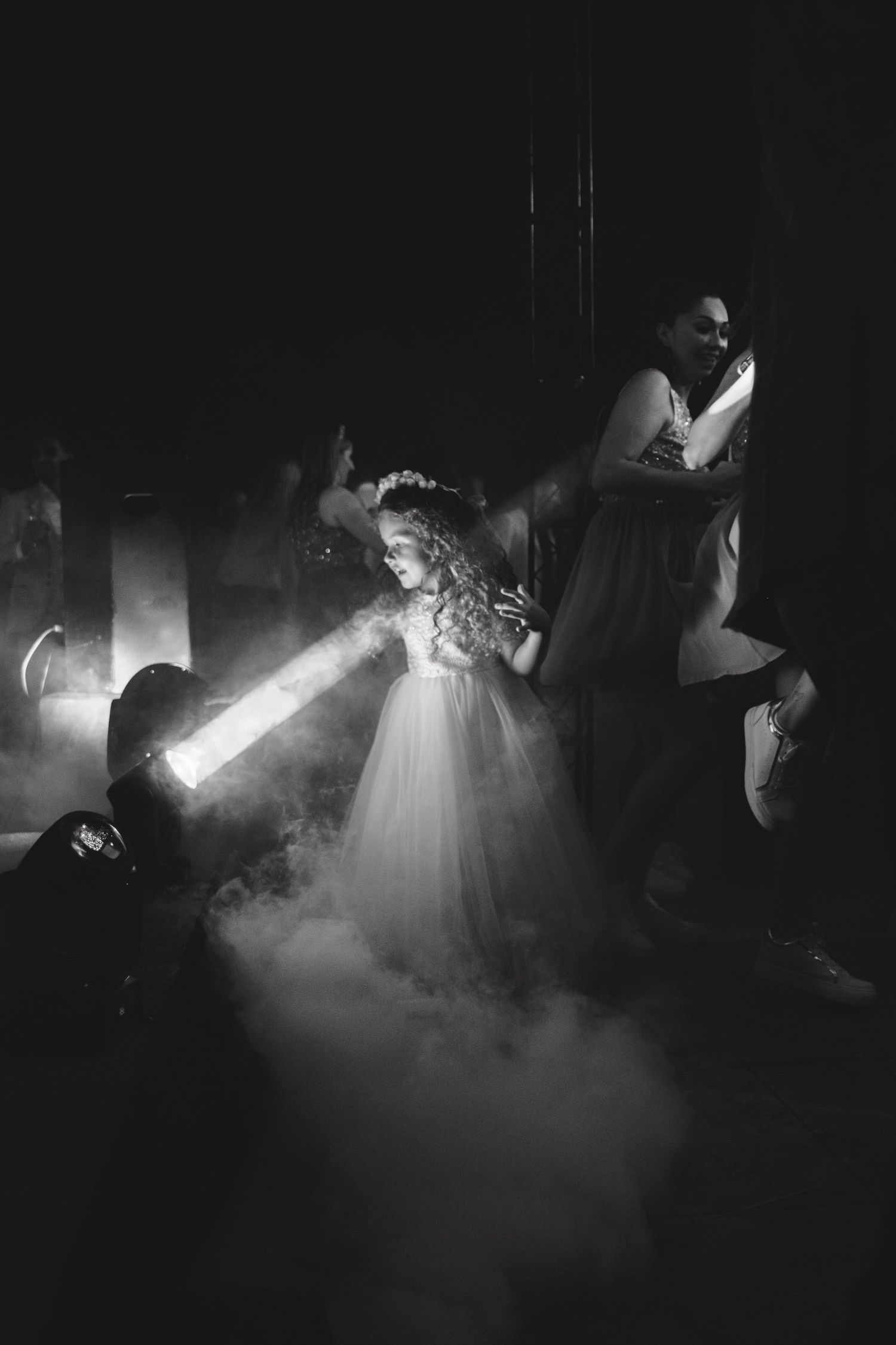 Atmospheric black and white shots of dance floor with fog and spotlights.