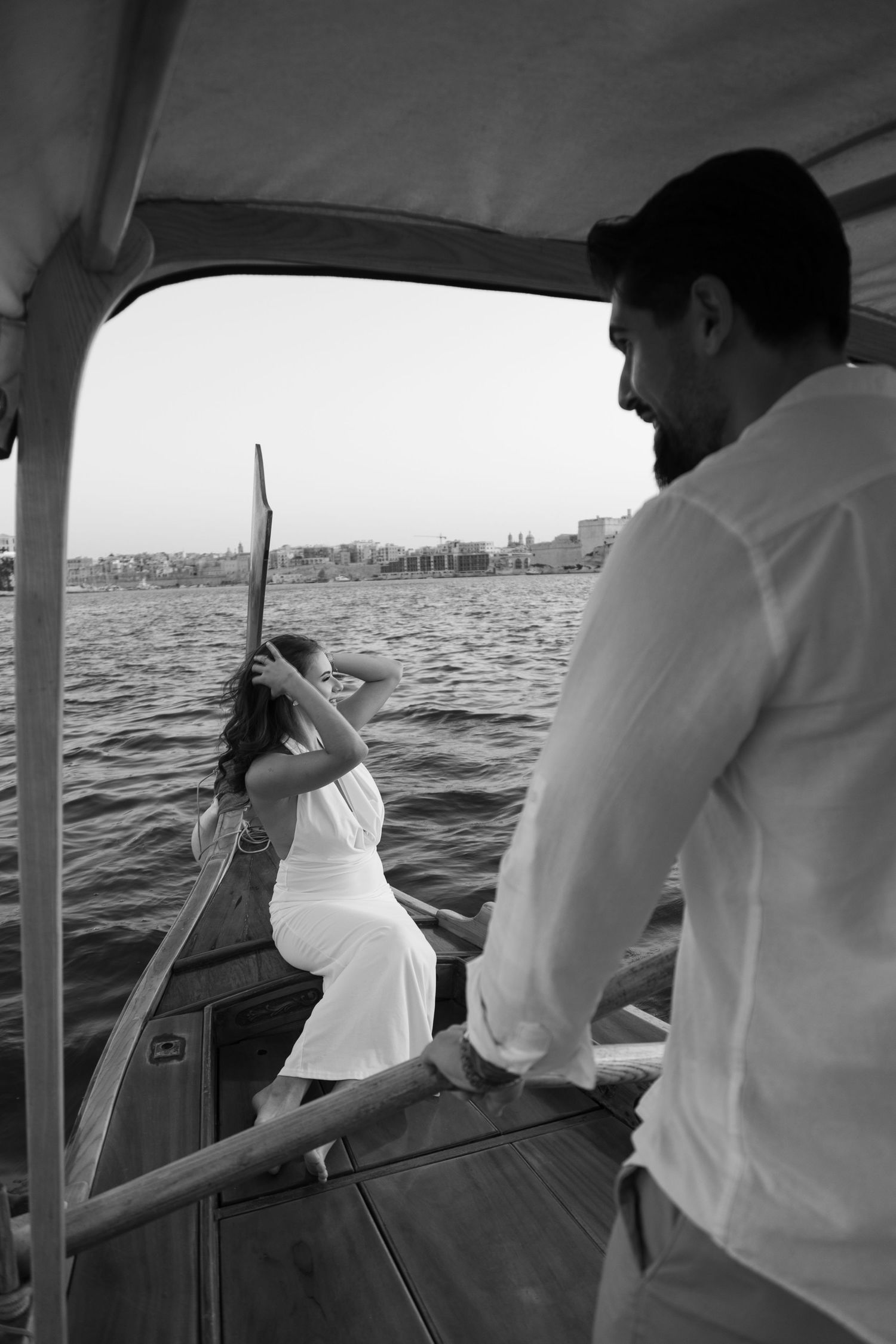 Series of black and white photos showing a couple's romantic boat journey at sea.