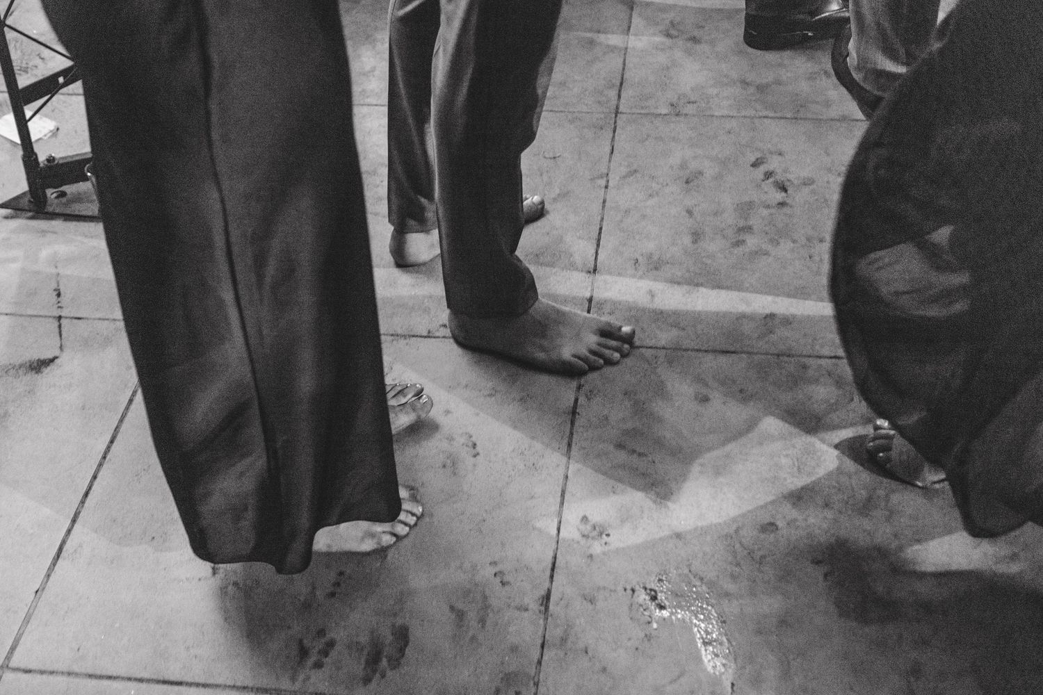 A detail shot of formal men's dress shoes and trousers on a dance floor.