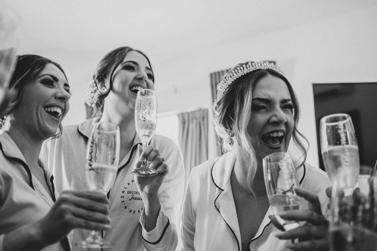 Black and white candid shots of a wedding party sharing laughs and drinks during celebration.