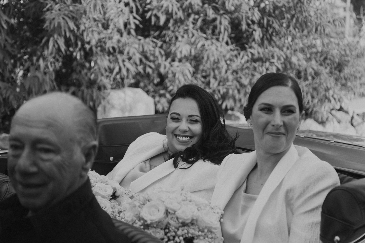 Black and white photo of people sitting together outdoors.