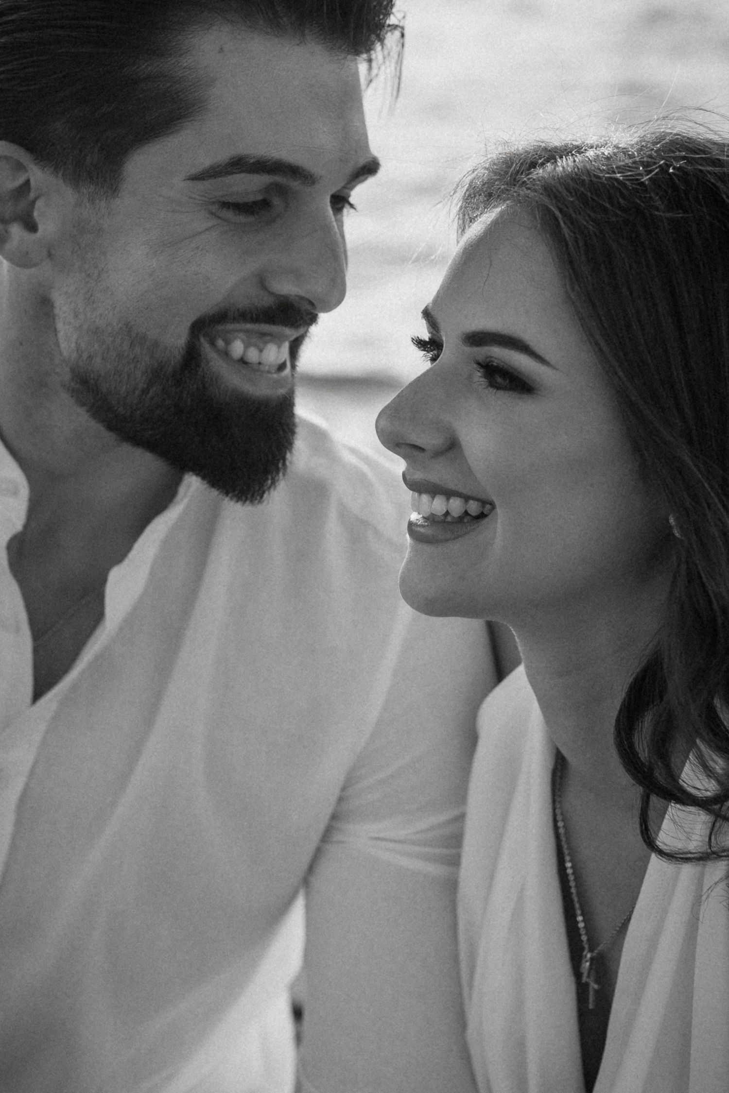 Black and white close-up captures candid laughter and joy between couple.