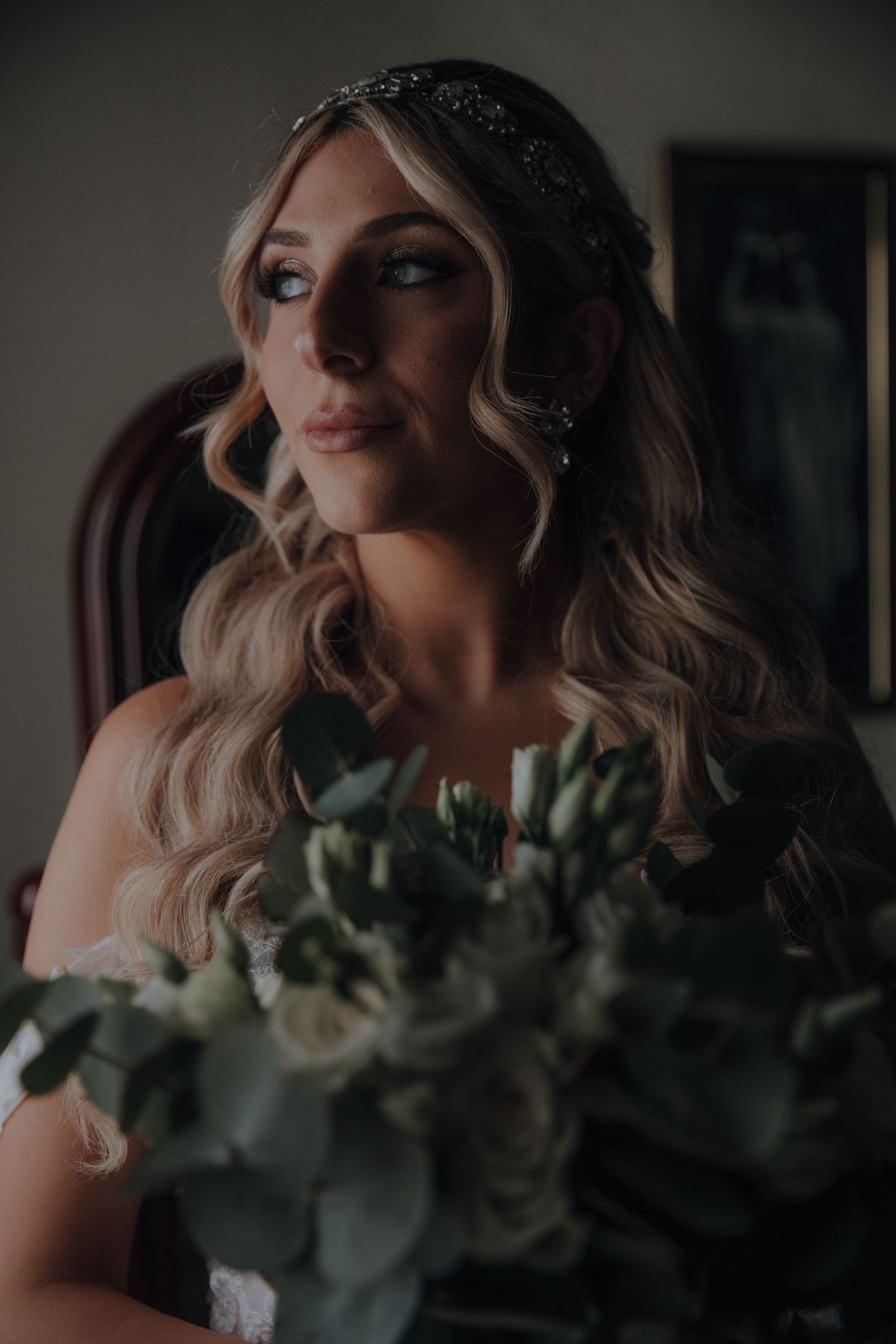 Bridal portrait featuring elegant makeup and a sparkly headpiece with eucalyptus bouquet.
