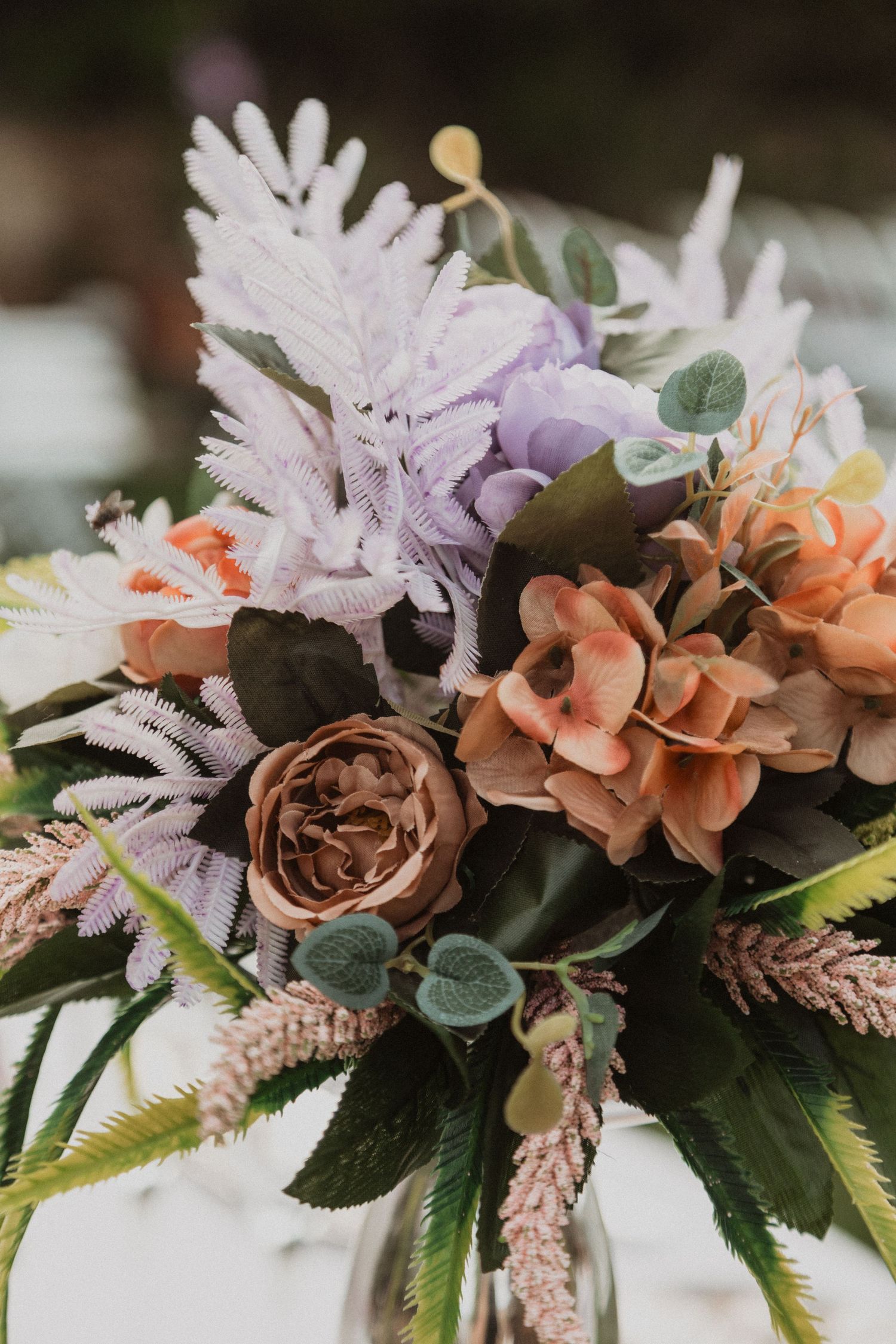 Romantic floral arrangement with soft pink and purple blooms mixed with delicate greenery.