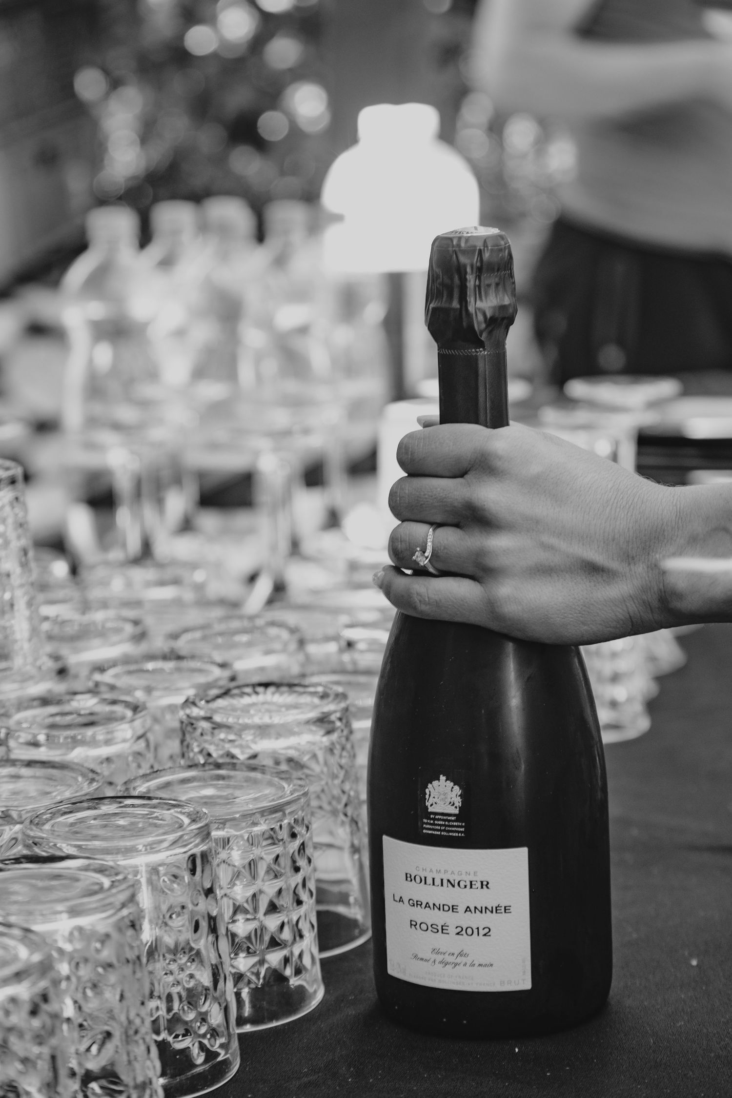 Wedding reception table setting with champagne bottles and crystal glasses.
