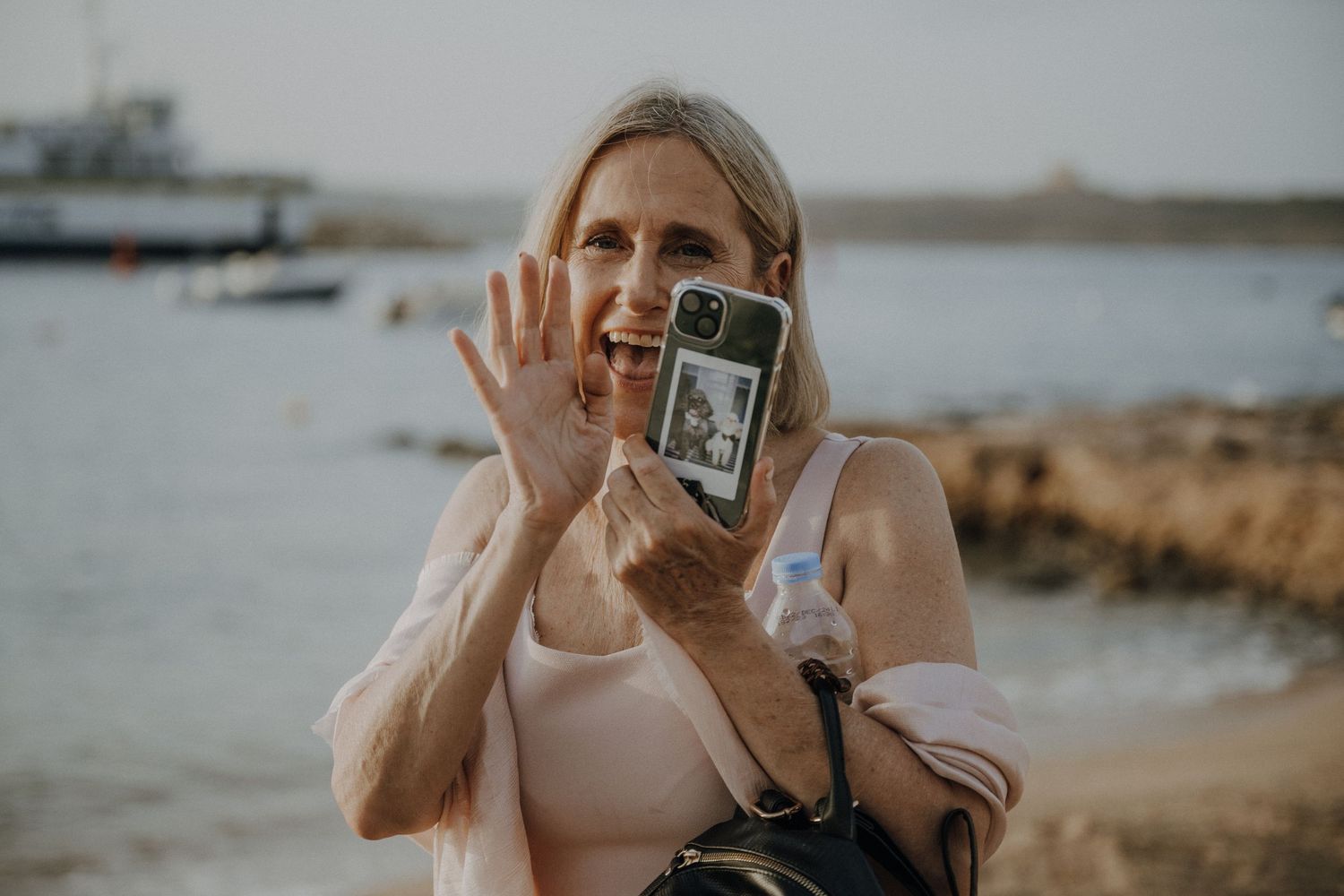 Wedding photographer shows a preview image on their camera display at a beach.