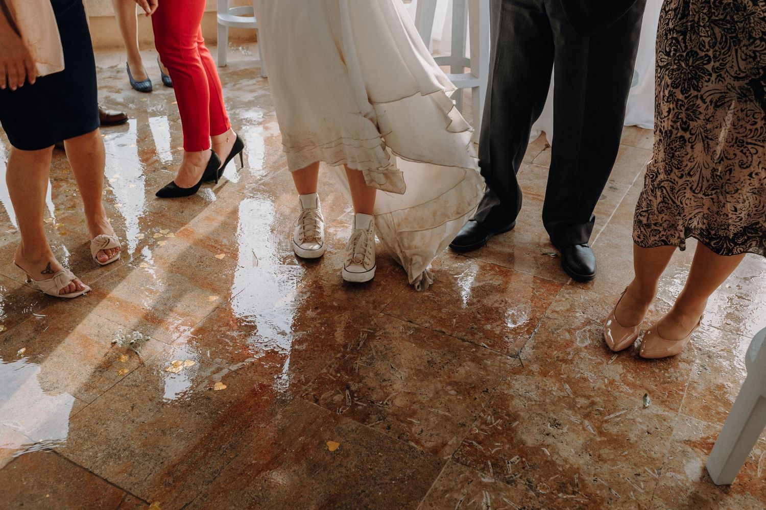Feet of wedding guests standing on a wet dance floor.