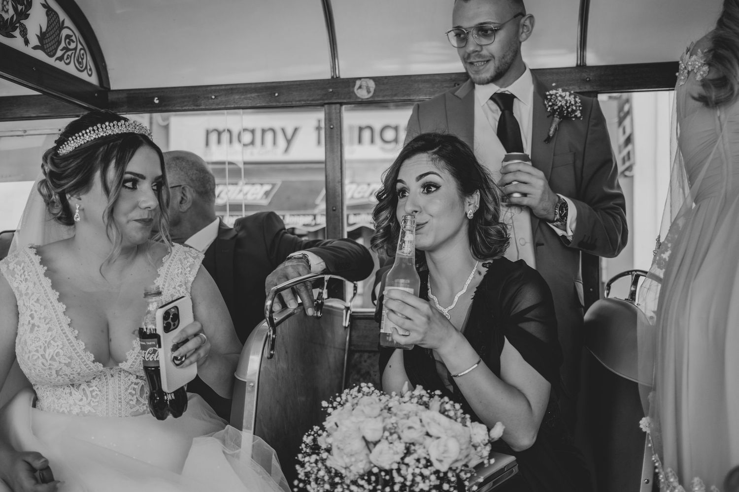 Wedding party enjoying drinks and celebration inside vintage bus transportation.