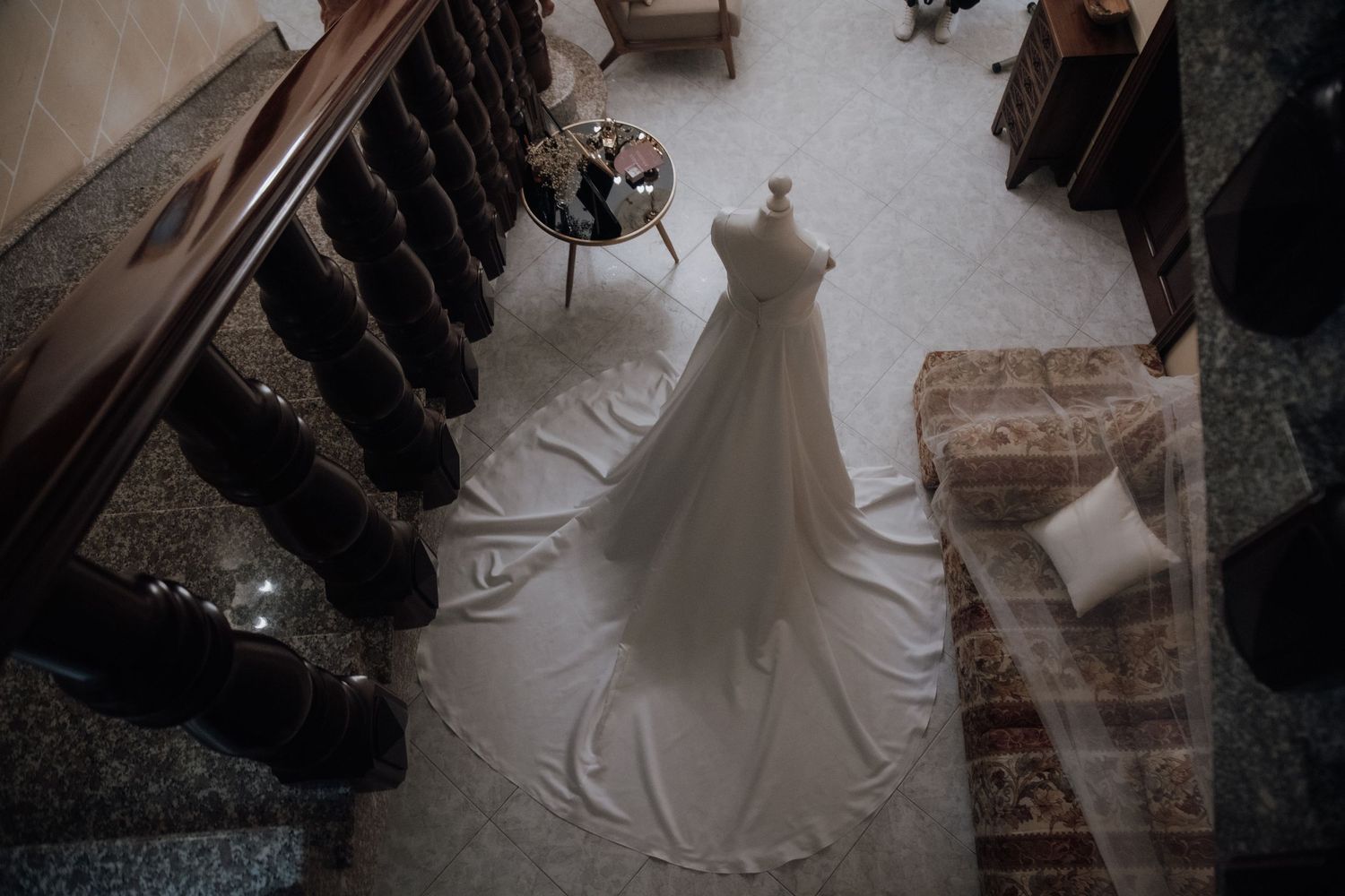 Wedding preparations with white gowns and formal attire being arranged in a room.