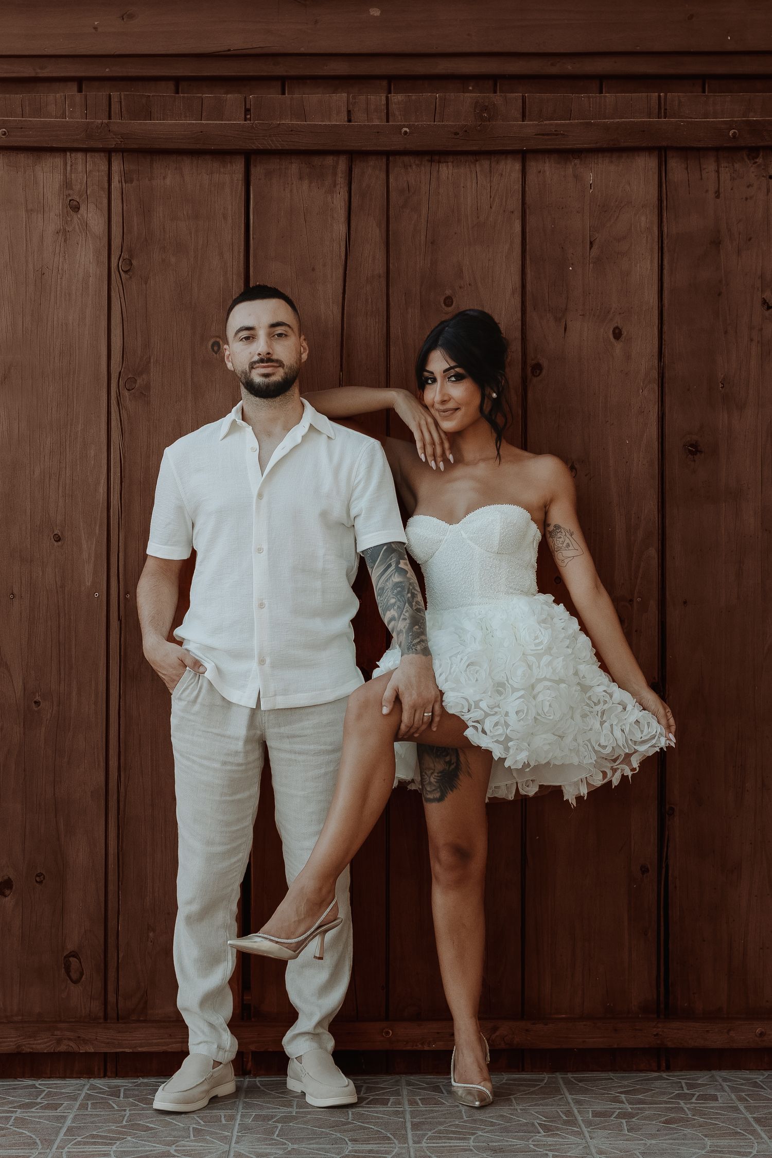Artistic wedding portraits against a wooden wall showing couple in white attire.