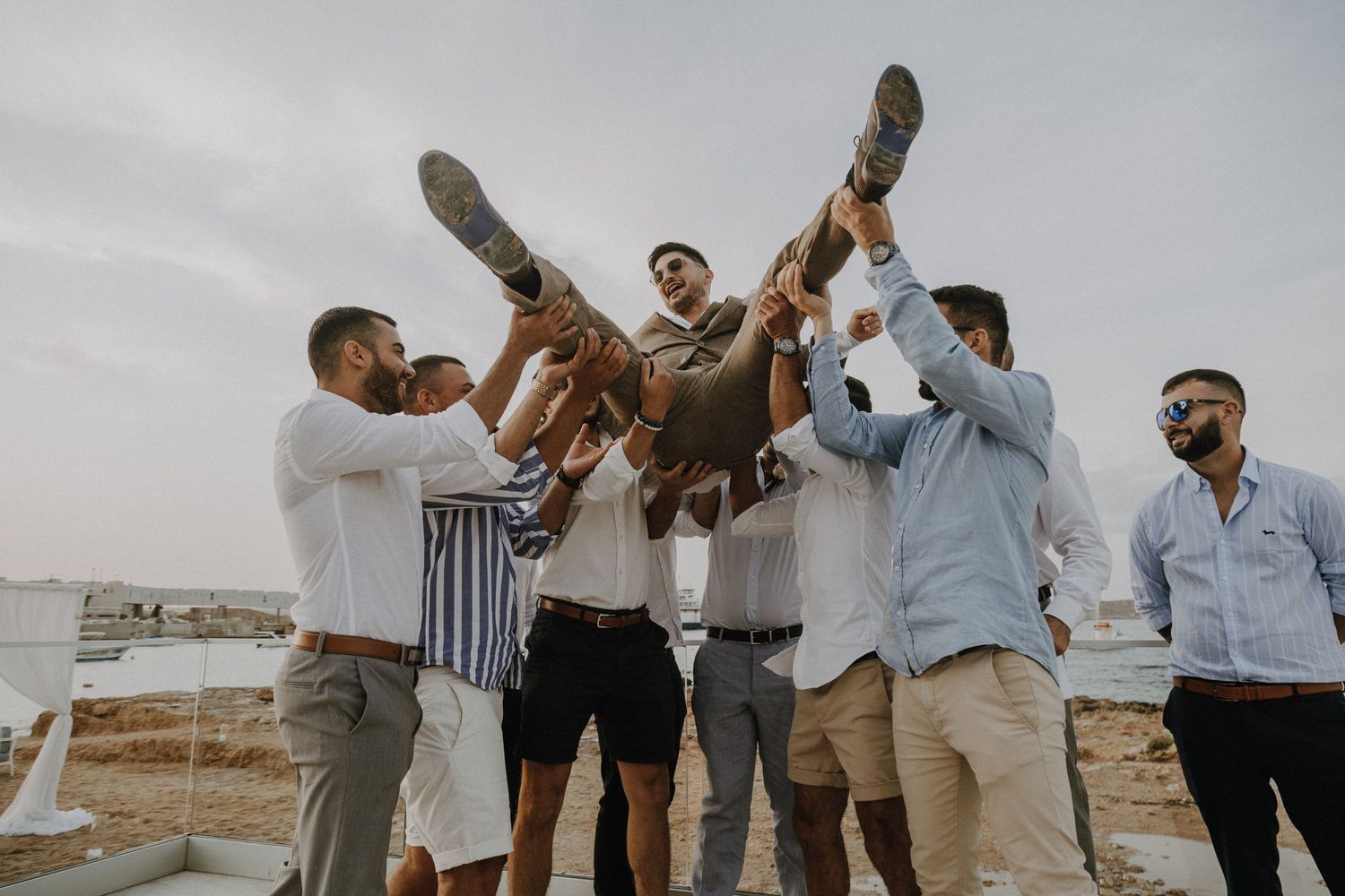 People jumping and celebrating outdoors wearing coordinated casual outfits.