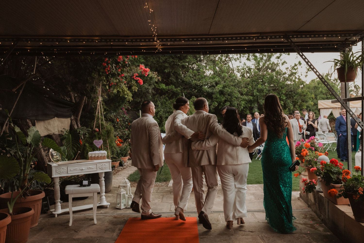 Outdoor wedding reception setup with white draping and floral decorations.