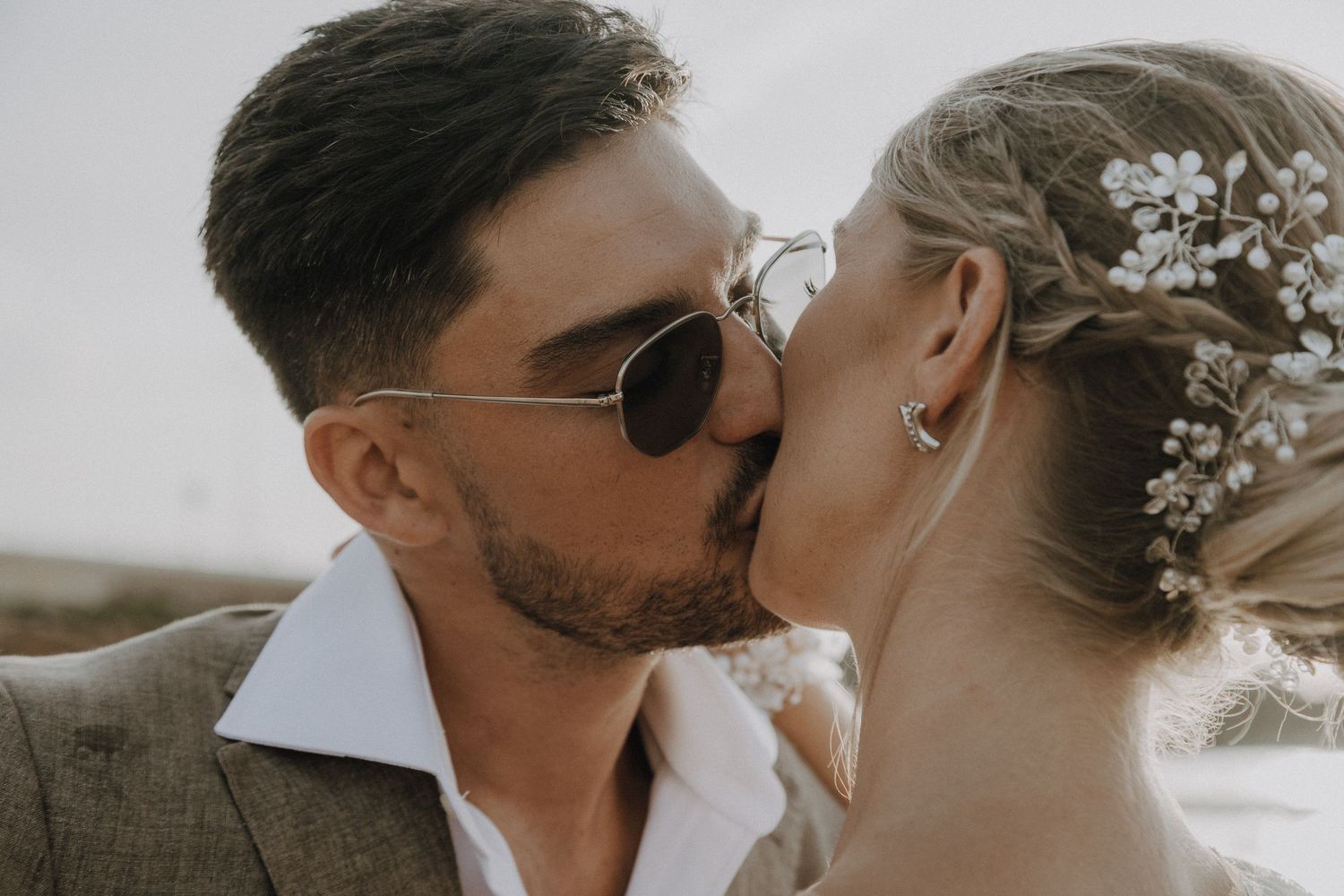 Romantic coastal wedding portrait showing tender moment between newlyweds.