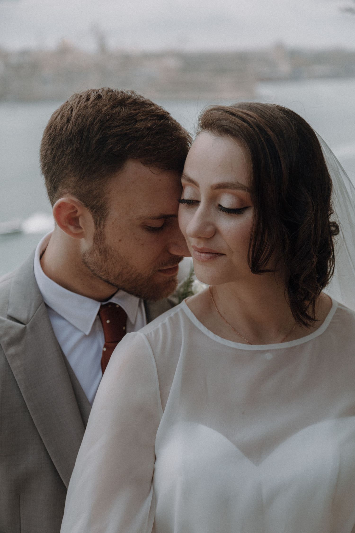 Intimate close-up wedding portraits in soft, moody lighting.