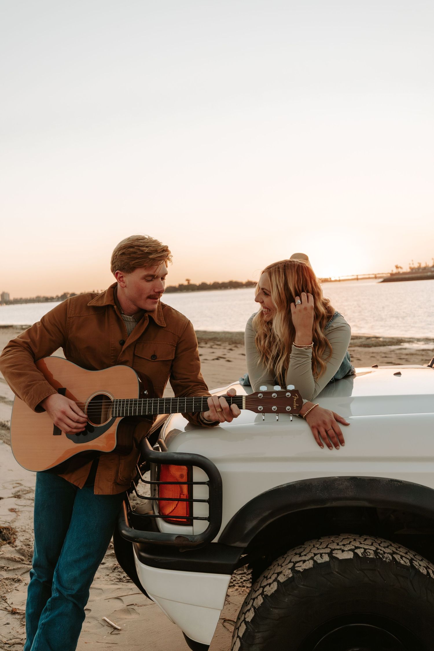 Couple playing guitar on the sandbar