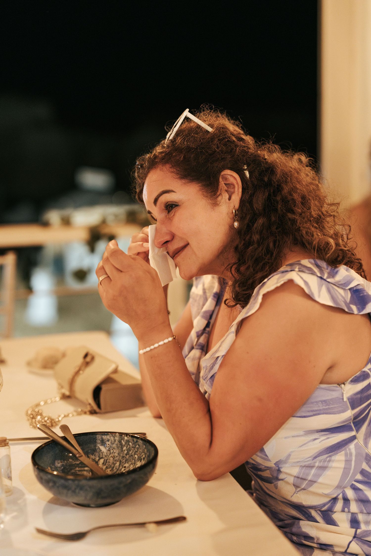 Guest in a blue and white dress enjoying dinner at an elegant event.
