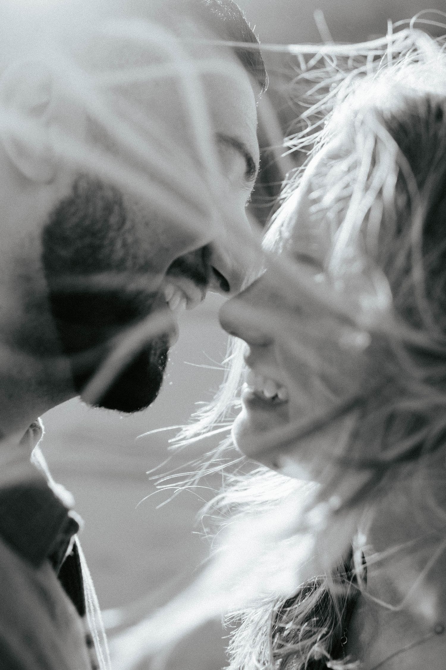 An intimate black and white close-up portrait of a couple sharing a passionate moment together.