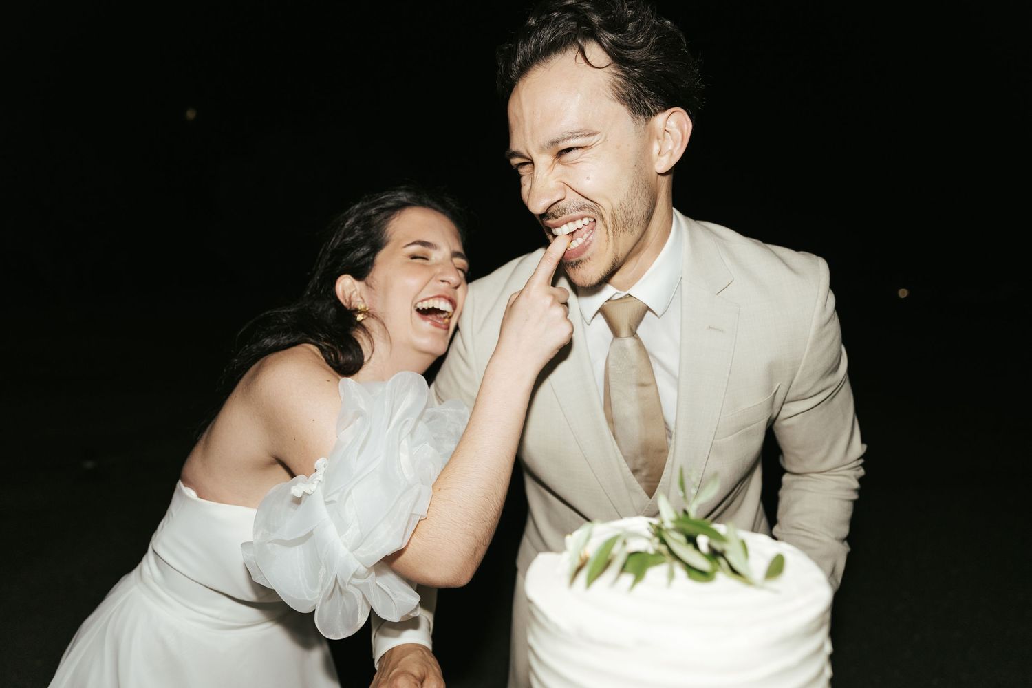 A couple in wedding attire shares joyful laughter during a series of candid black and white photo moments.