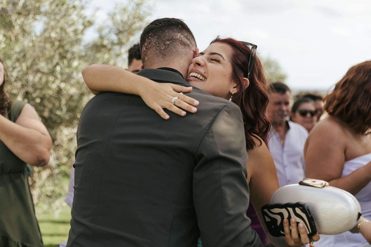 Joyful celebration moment between guests at an outdoor wedding event.
