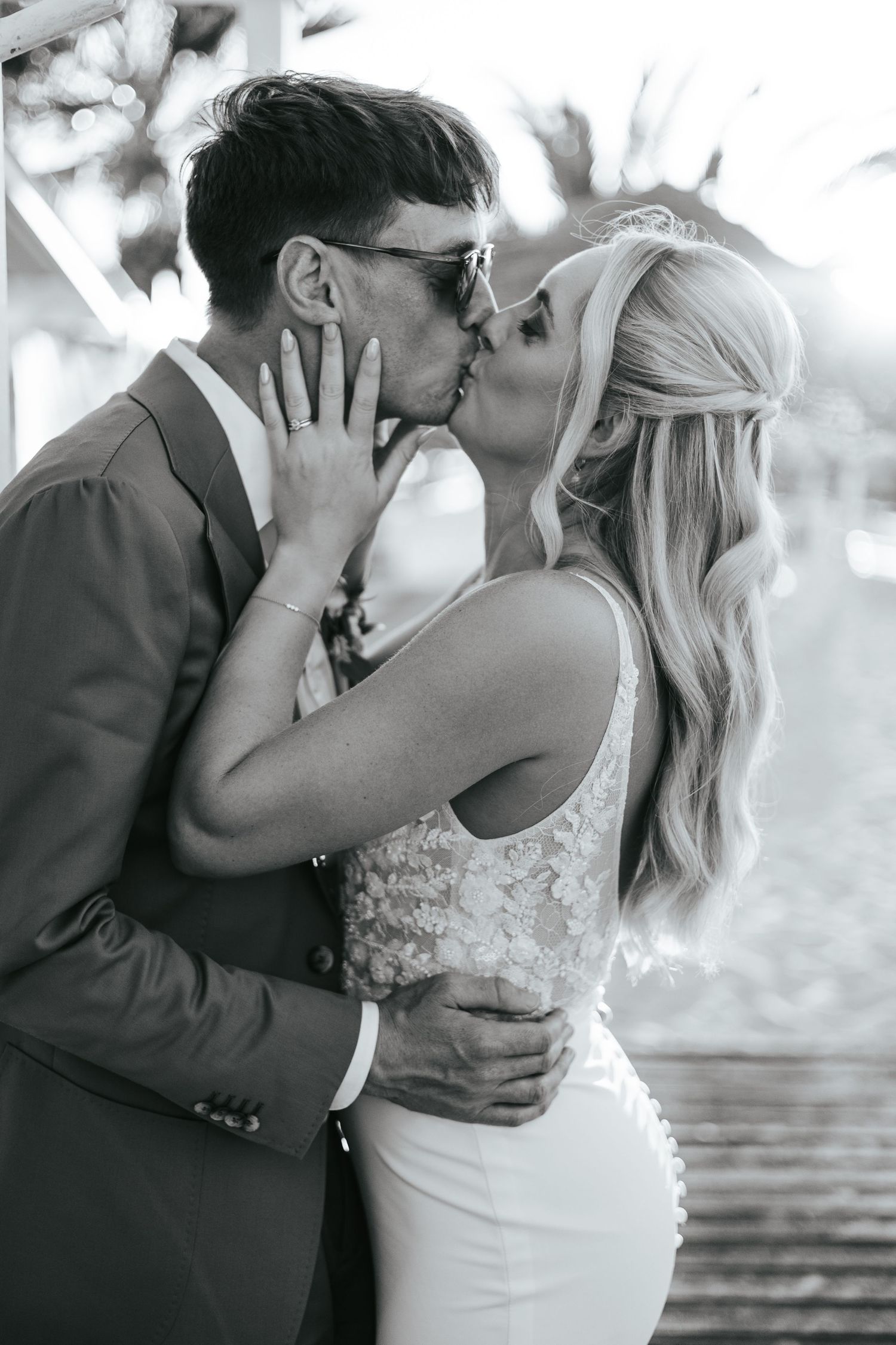 Black and white romantic wedding photos showing tender kisses between newlyweds in an intimate sequence.