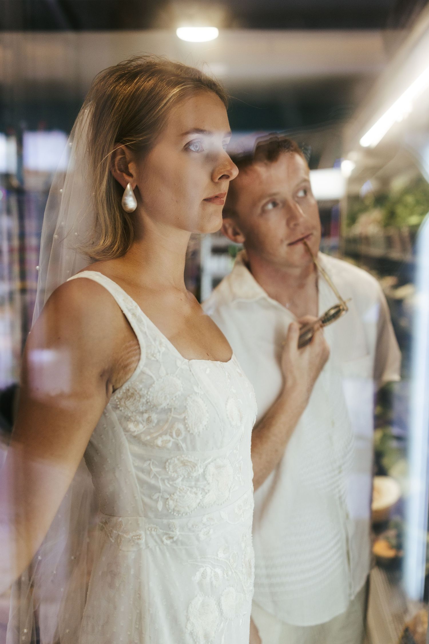 A series of candid wedding preparation moments showing final touches being applied to a bride in a white lace dress.