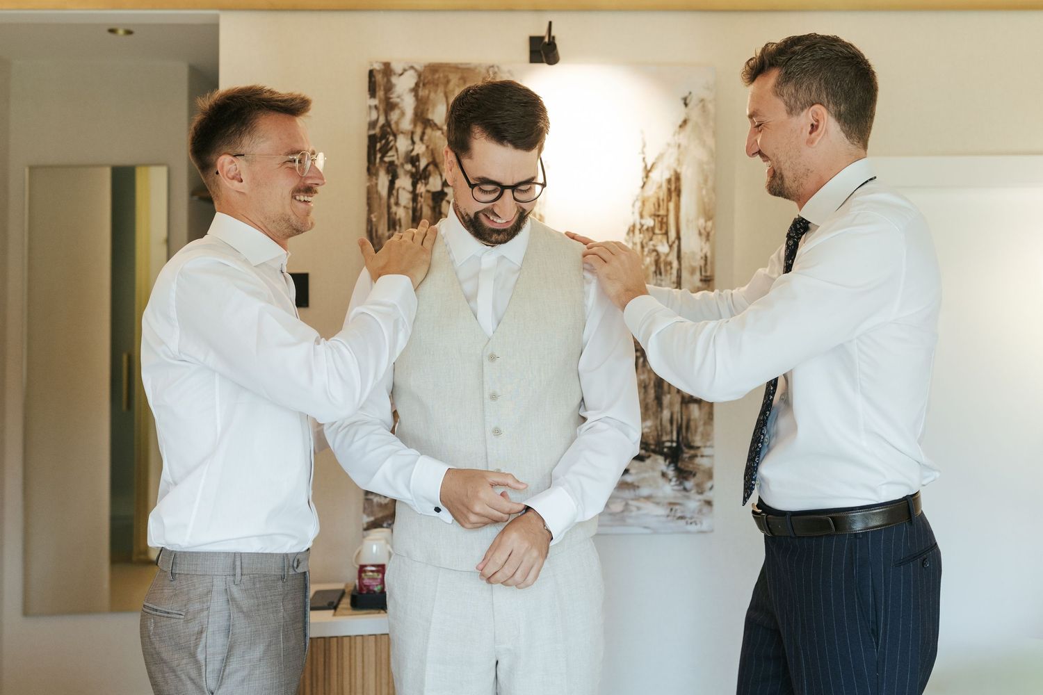 Group wearing formal white shirts and dress pants during wedding preparations.