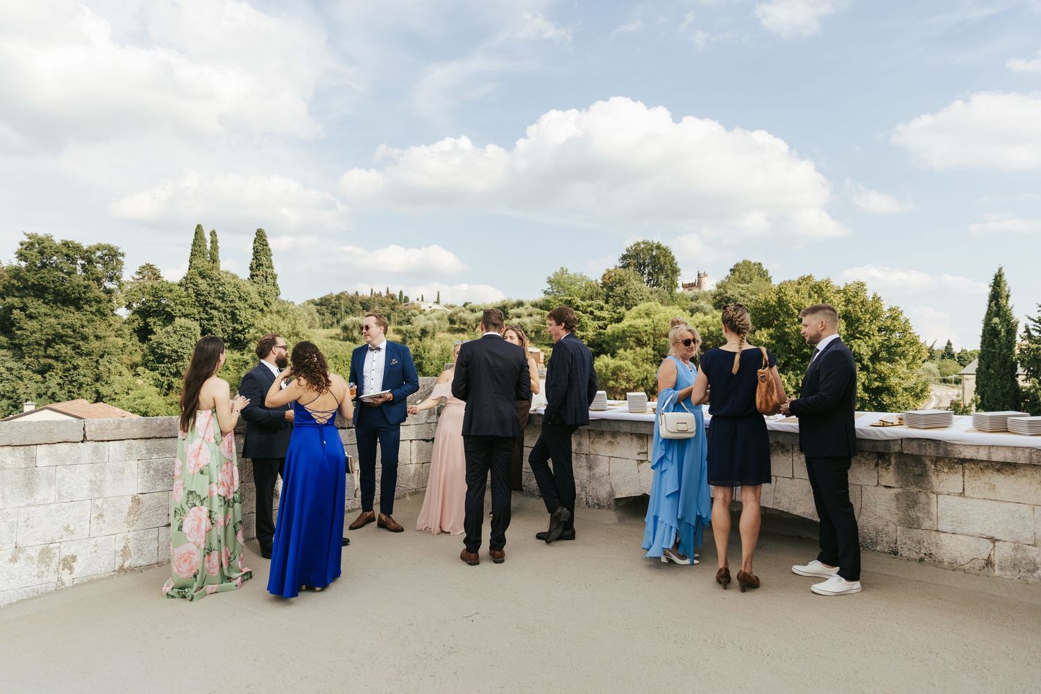 Group gathered on stone terrace overlooking scenic landscape.