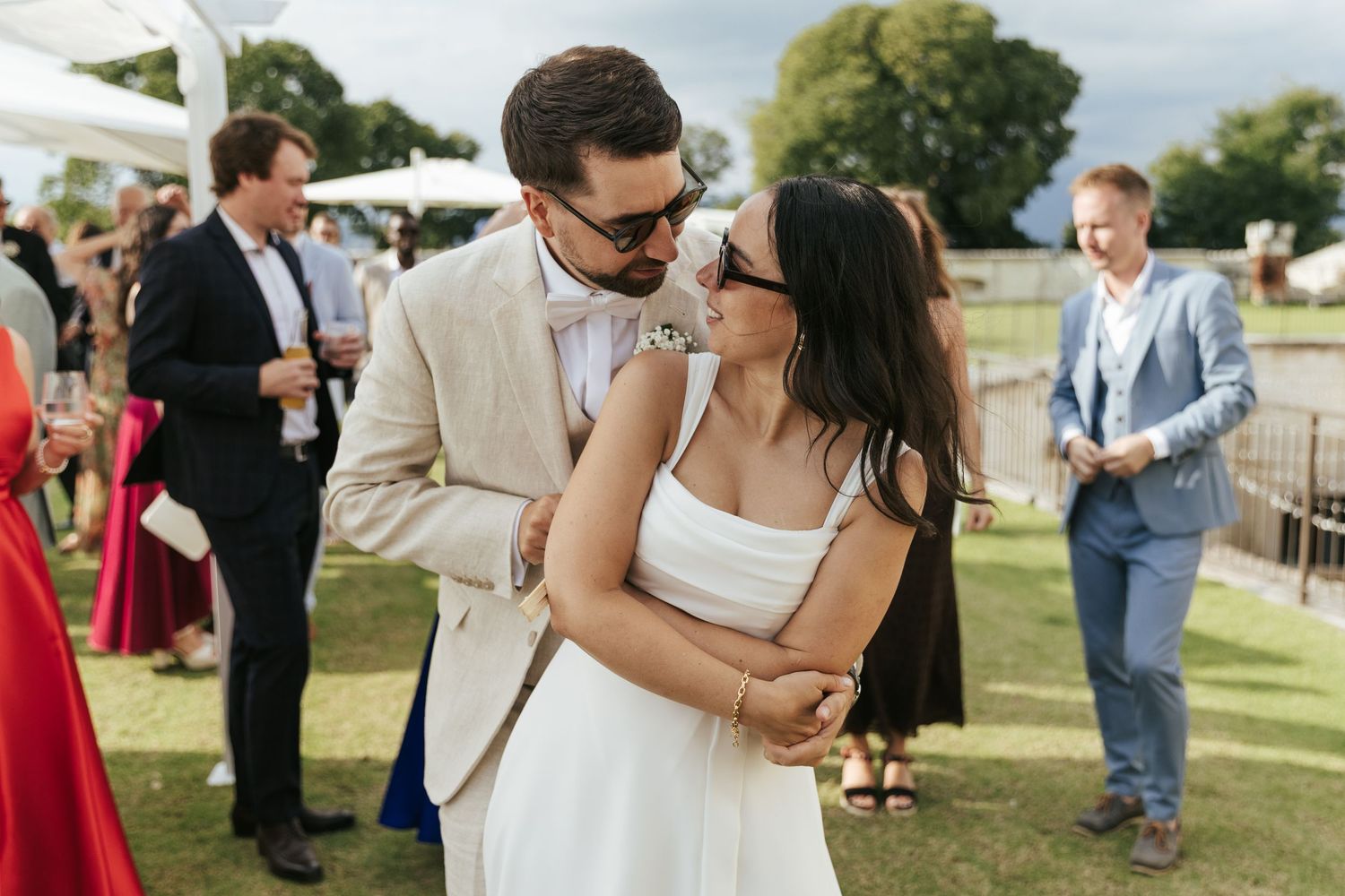 Joyful celebration moments captured at an outdoor wedding reception with guests in formal attire.