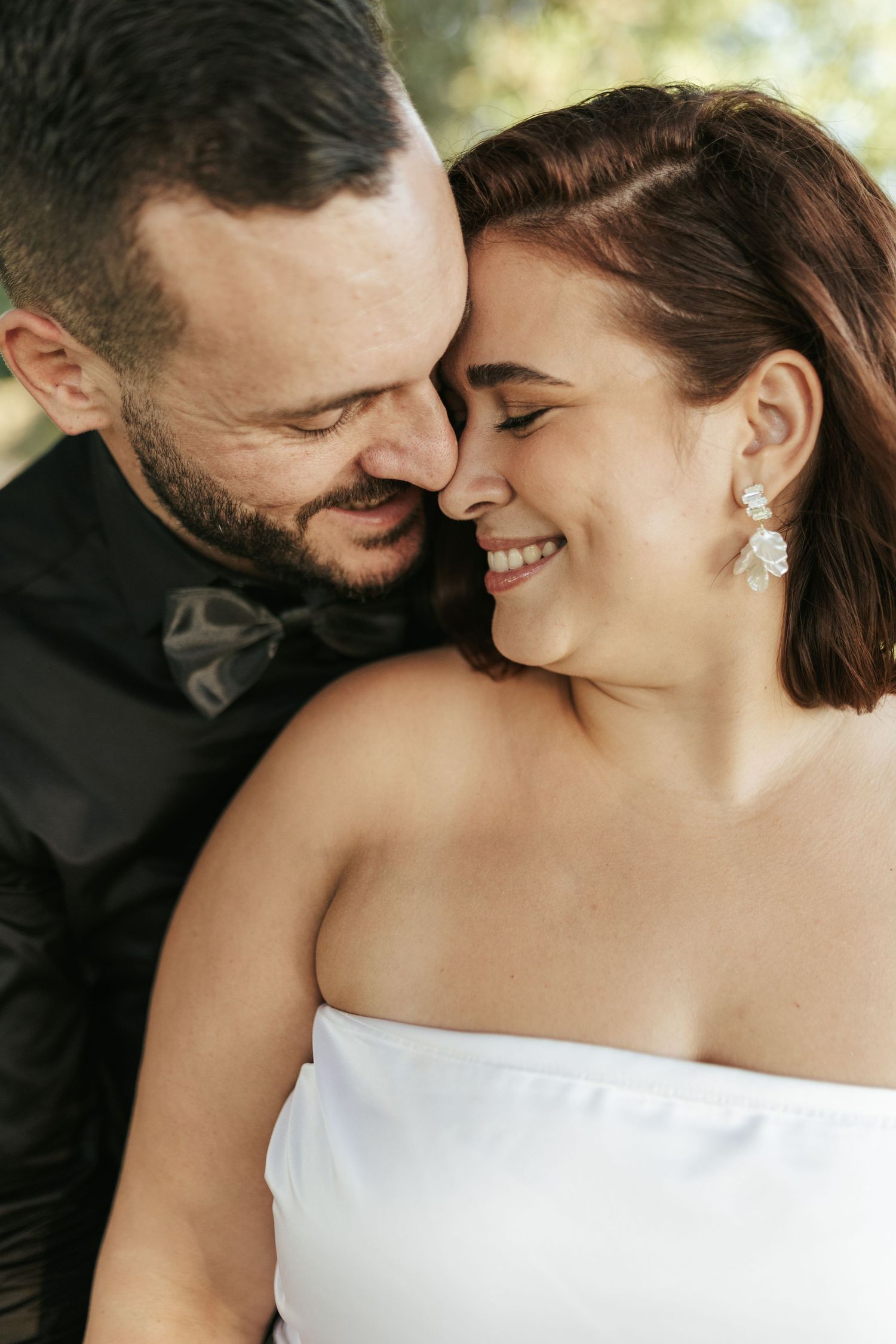 Intimate moment between newlyweds as they share laughter during their wedding photoshoot.