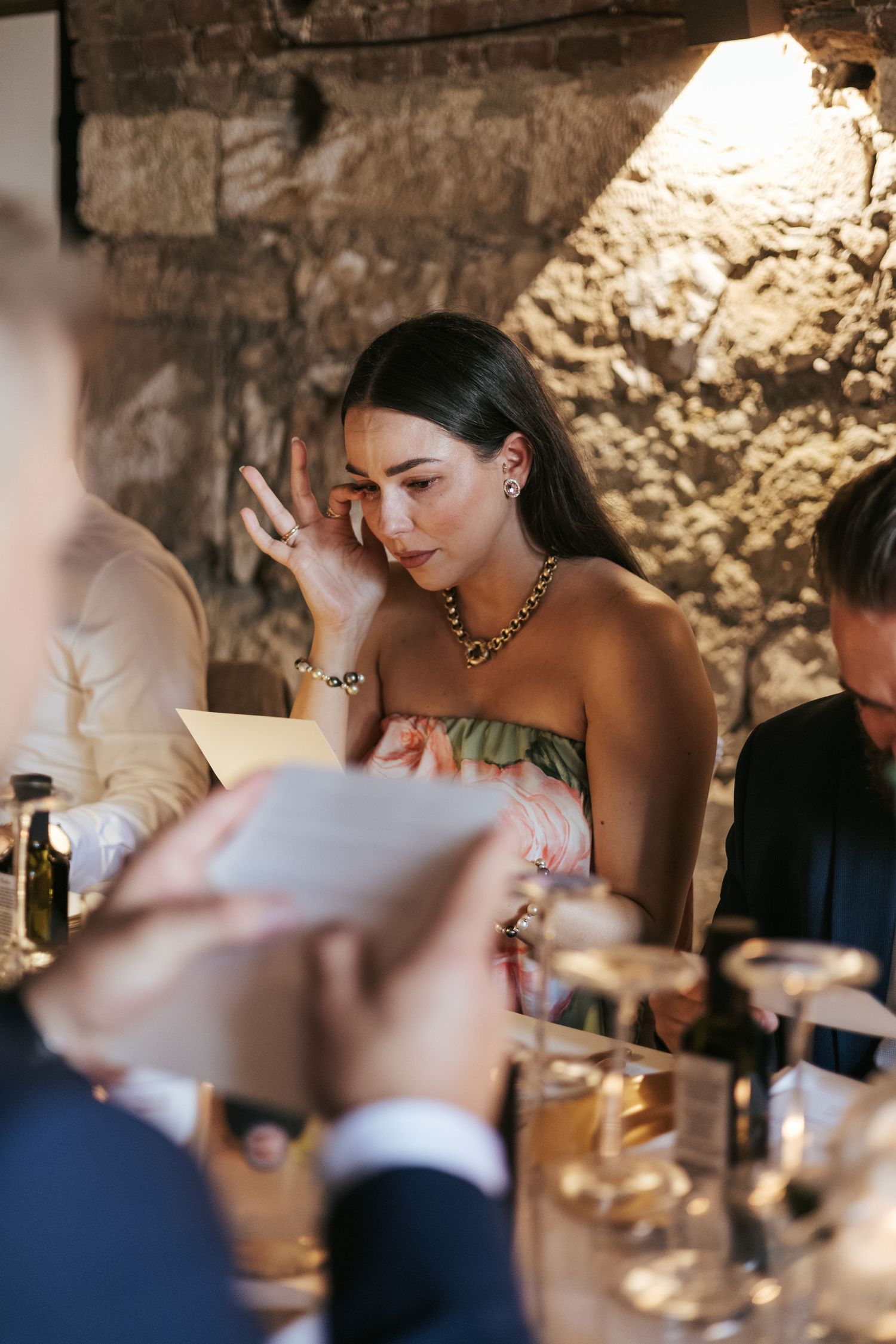 Elegant wedding reception dinner scene with candlelight and stone walls creating romantic ambiance.