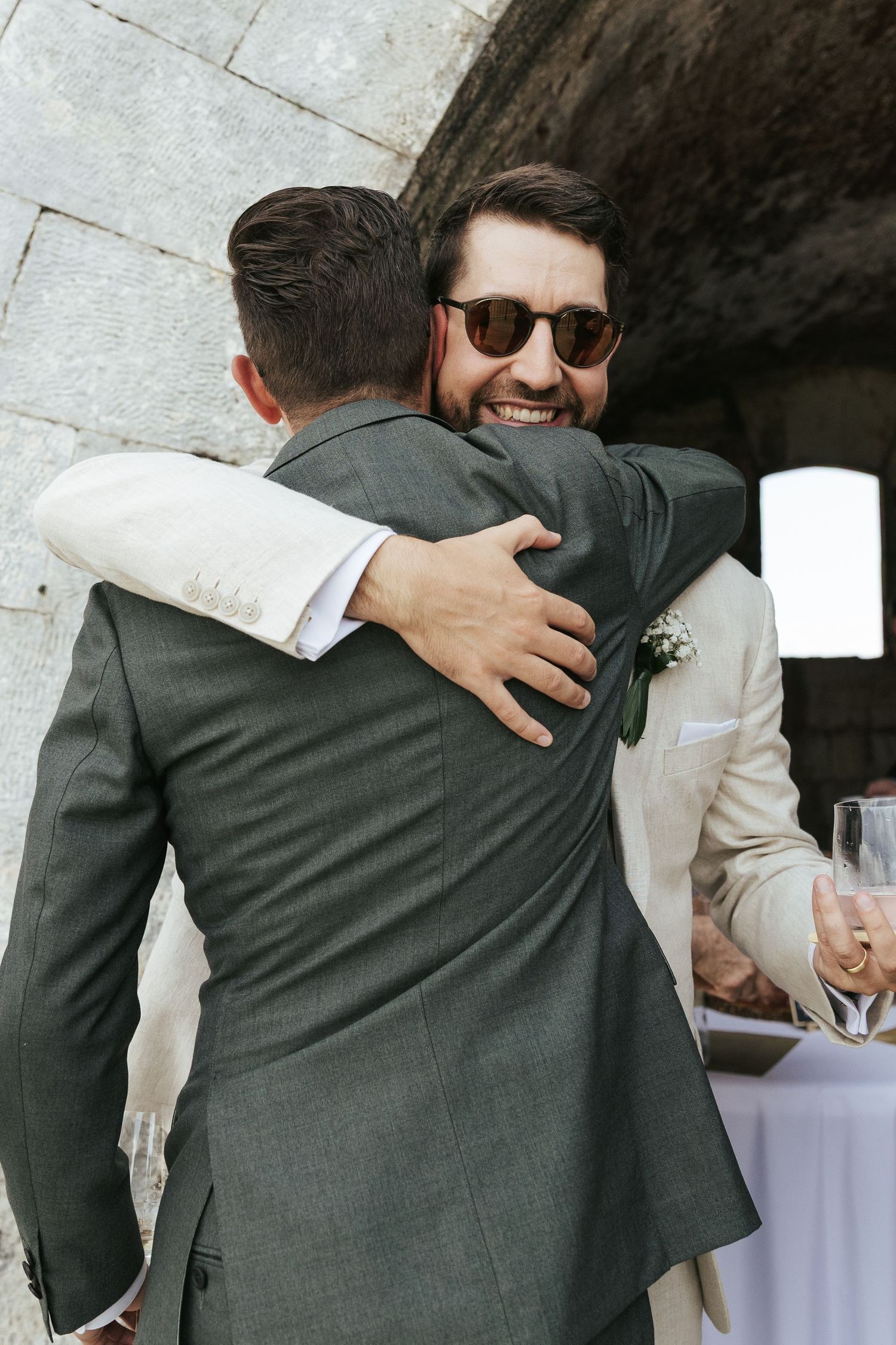 Two guests sharing a celebratory hug at an outdoor event.
